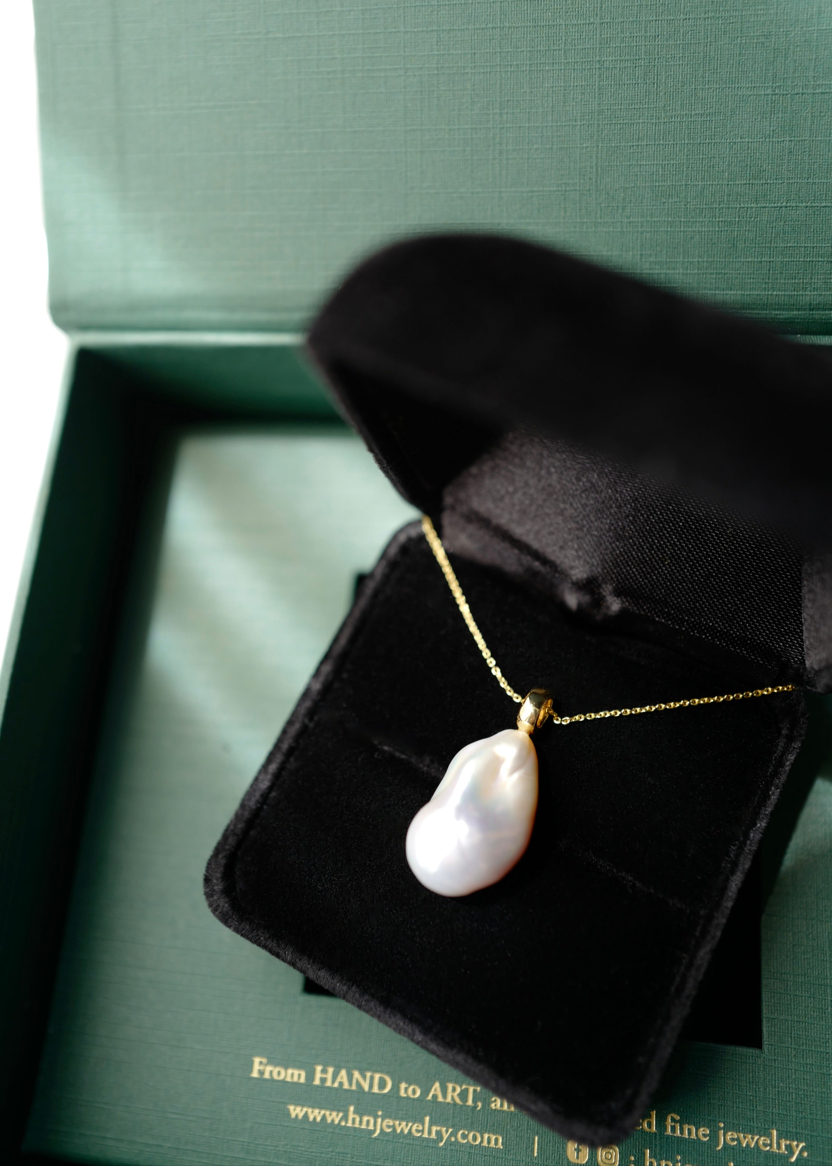 Pearl necklace in a black jewelry box on a green background