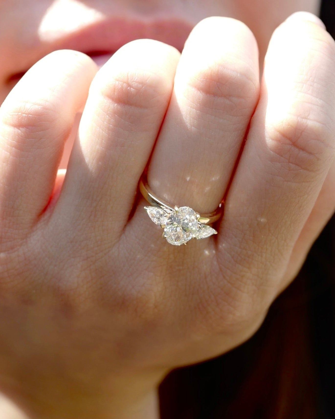 Close-up of a hand wearing a diamond ring with a blurred background