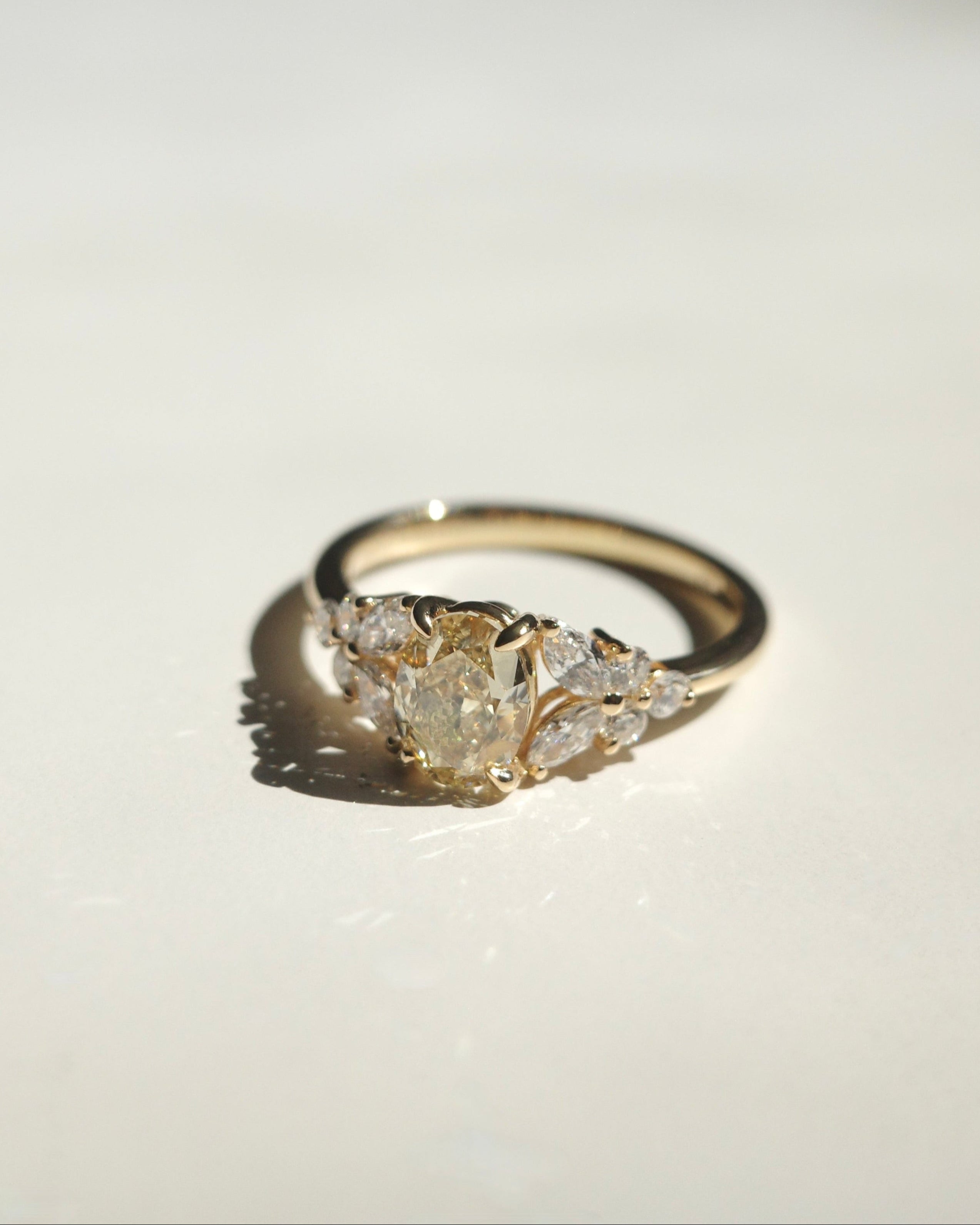 Gold ring with diamond cluster on a white background