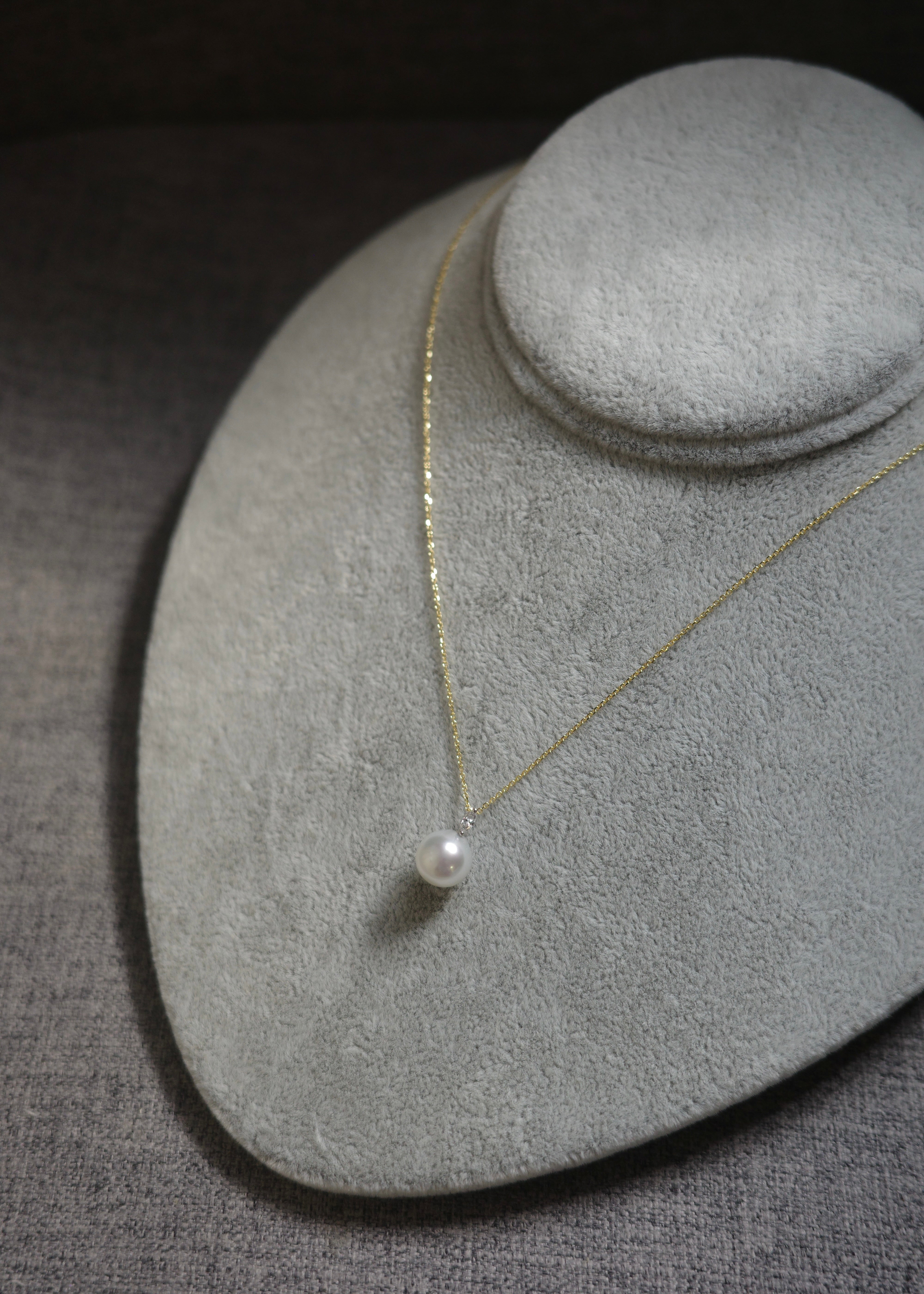 Pearl necklace on a gray jewelry display