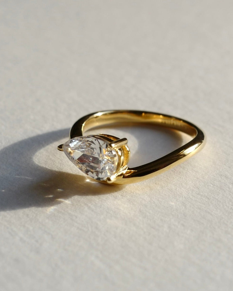 pear diamond pinky ring in 14k solid gold on a light gray background
