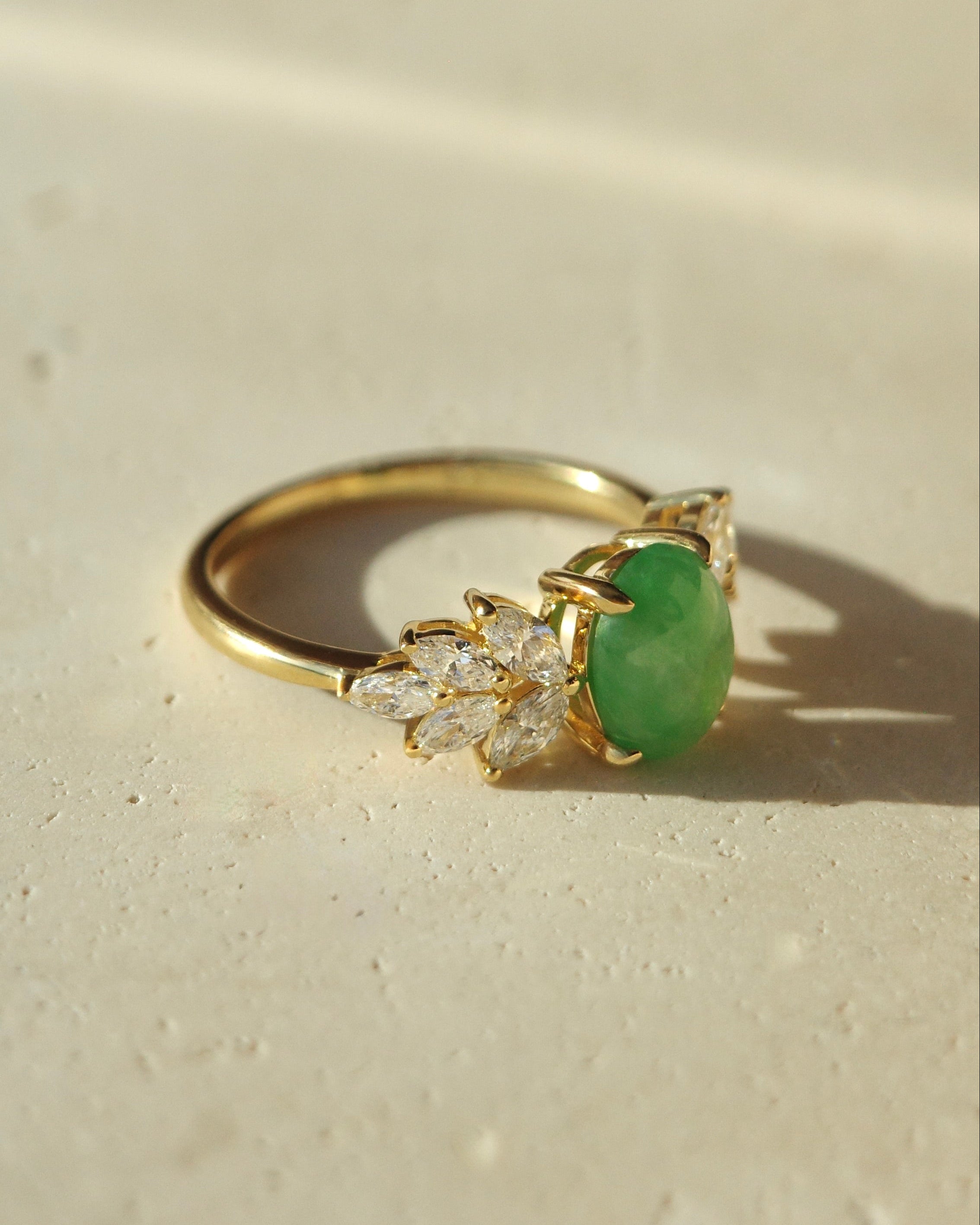 Oval green jade engagement ring with marquise diamonds in 14k yellow gold