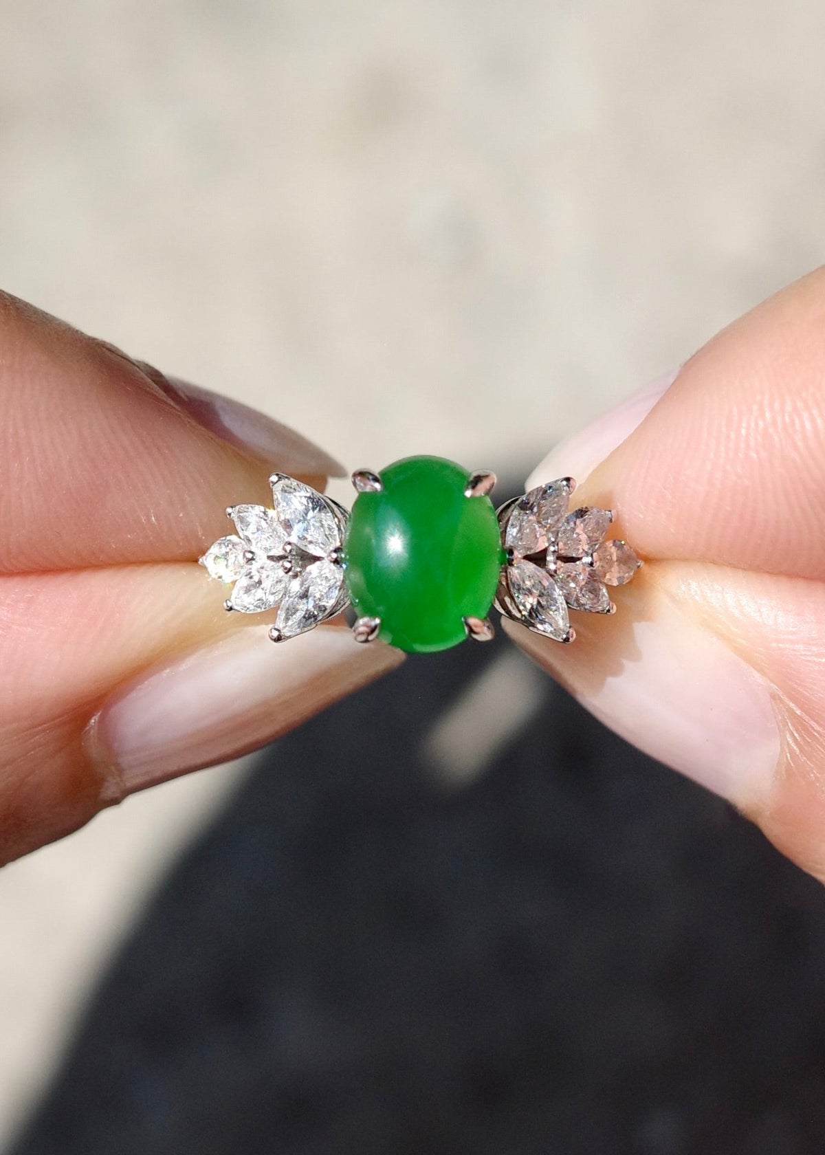 Vibrant translucent green Type A jadeite ring worn on finger in natural sunlight showing diamond foliage details