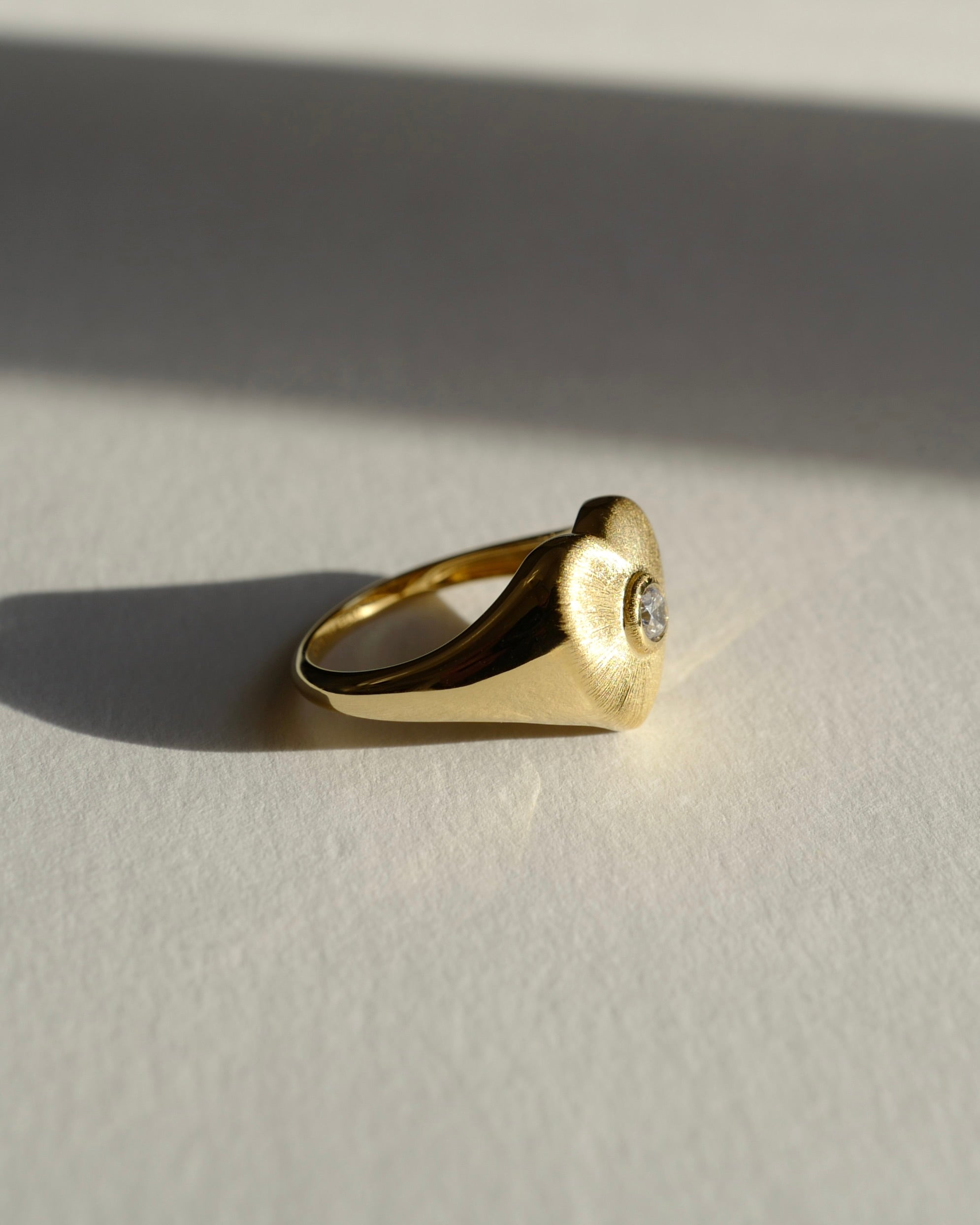 Brushed gold heart texture ring with sparkling diamond