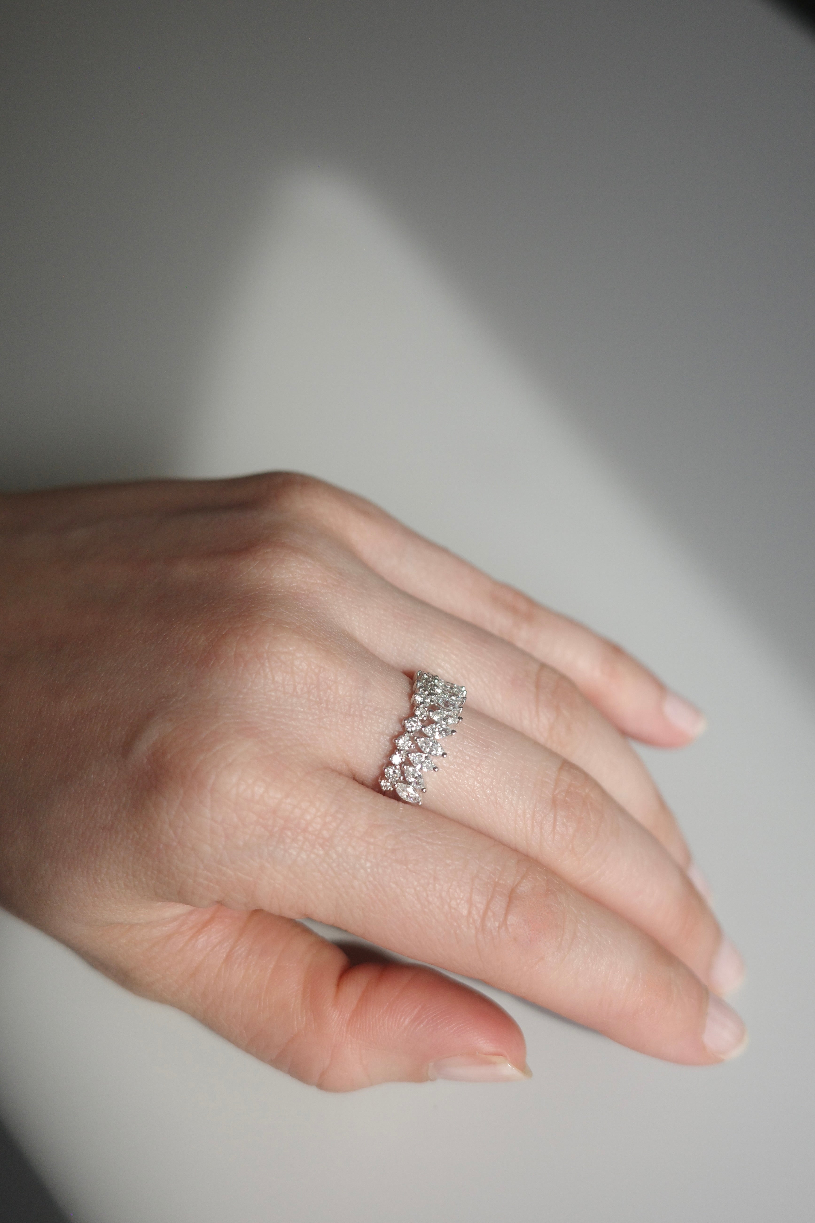 Crown-inspired diamond ring with marquise and round stones worn on hand