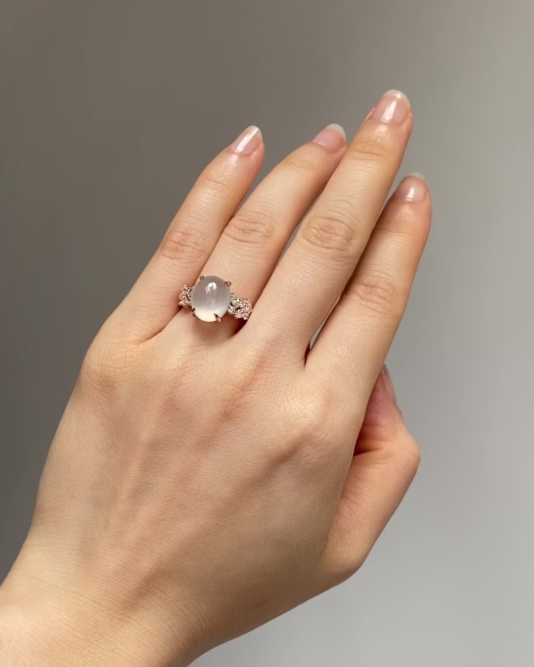 a model wear an oval icy white jade and diamonds made in 14k rose gold