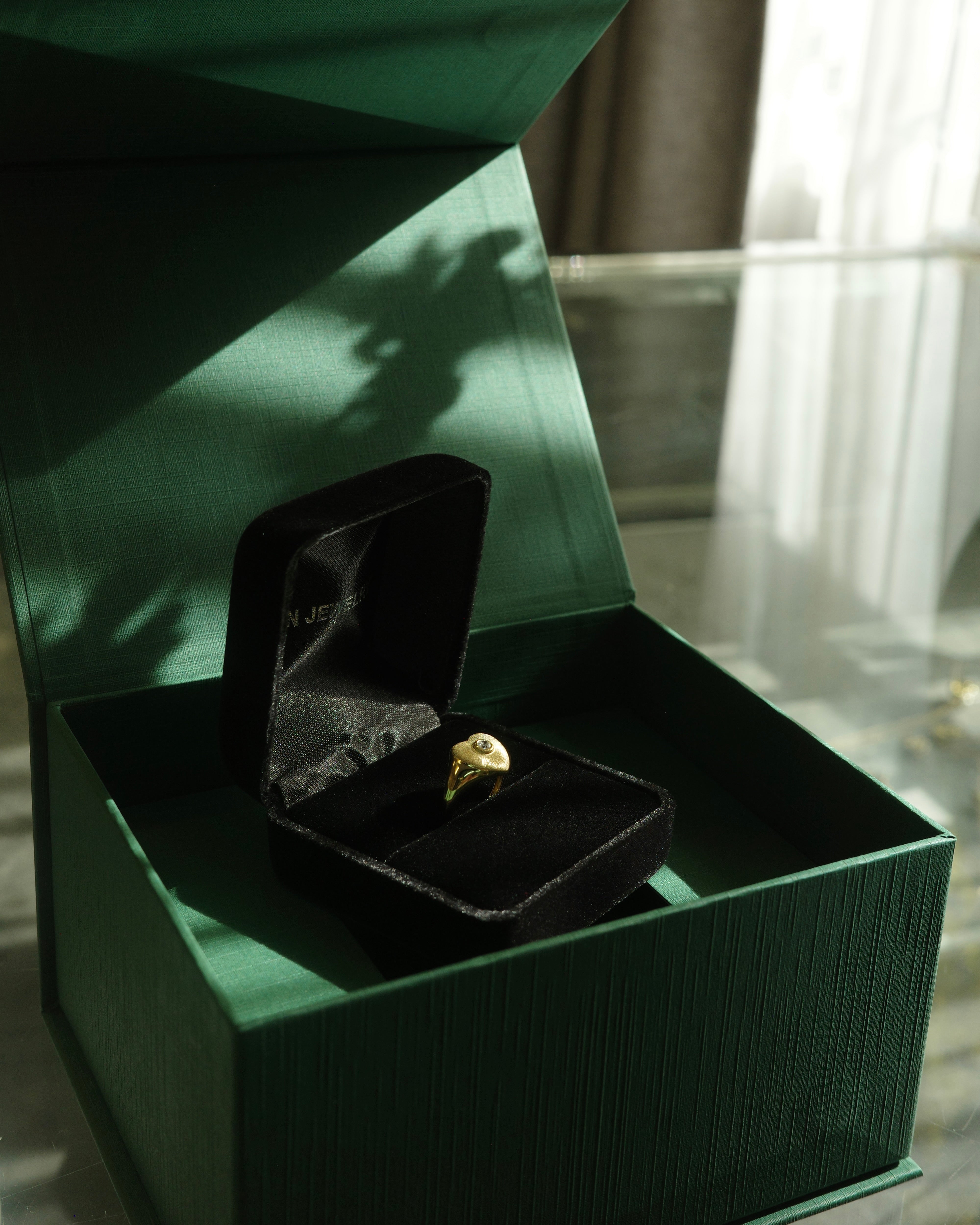 Gold textured signet ring with round brilliant cut diamond