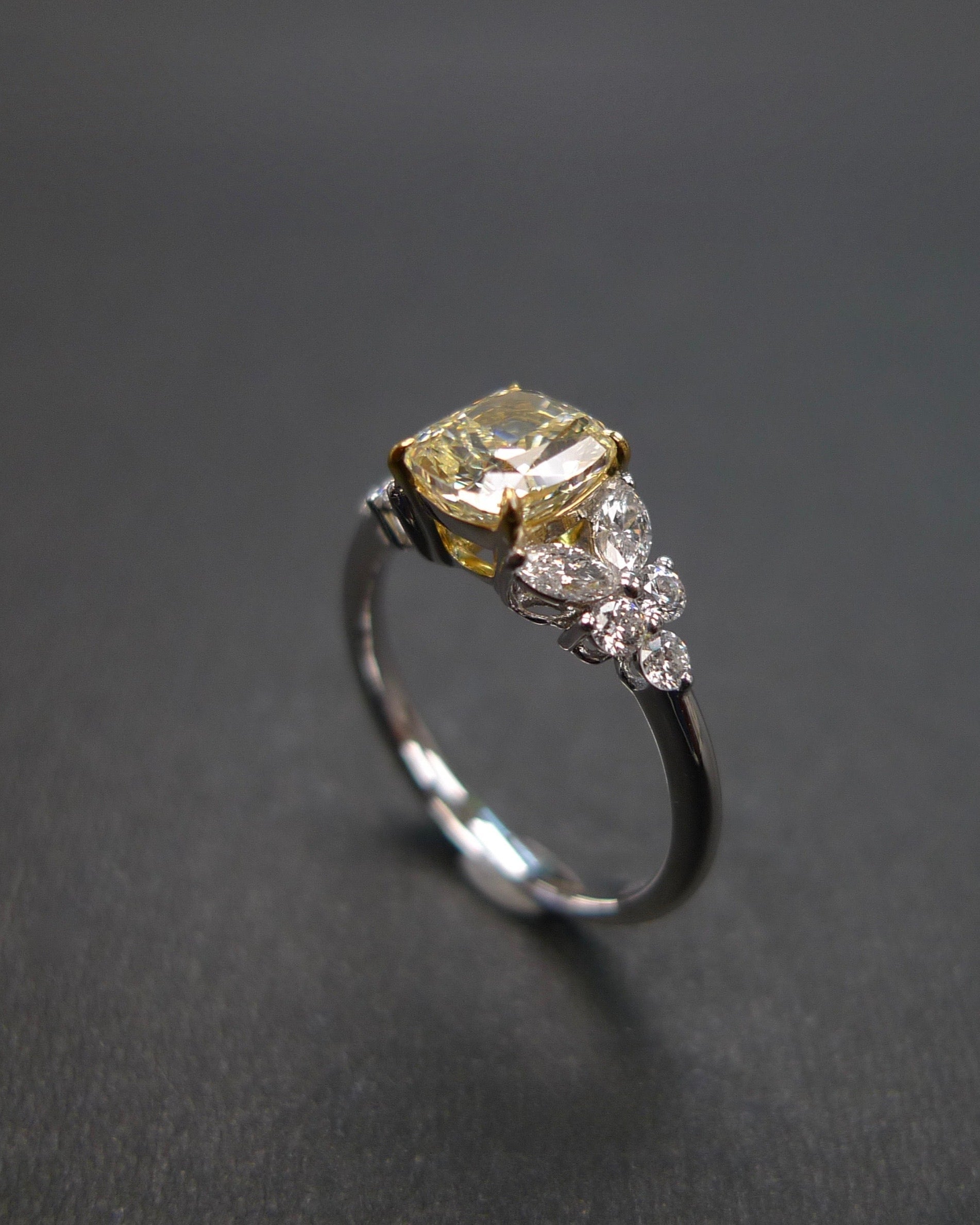 Unique yellow diamond engagement ring with cushion center and marquise side diamonds