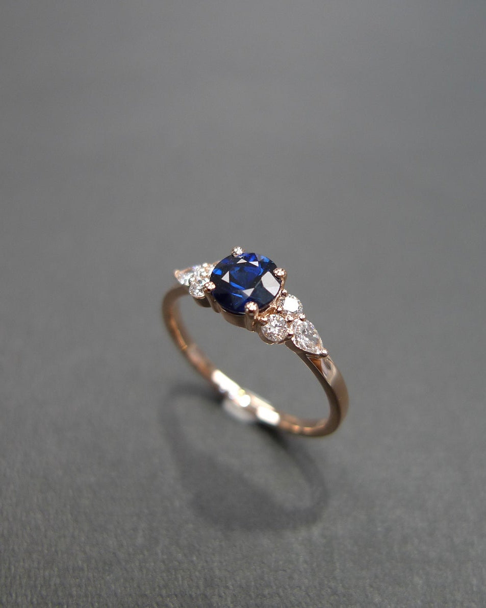 5mm round blue sapphire ring with pear and round diamond side stonesY