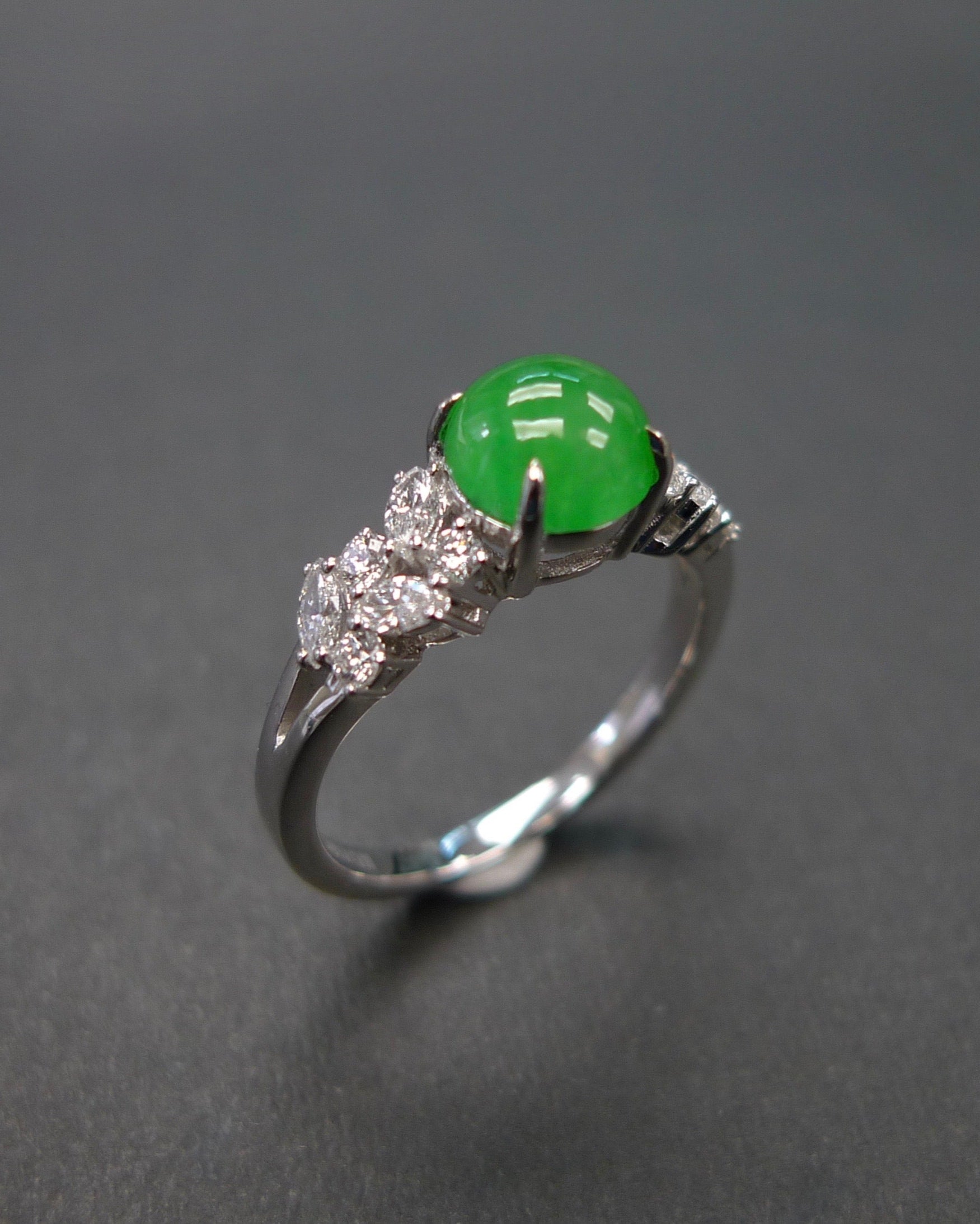 an engagement ring set with round green jade and marquise and round diamonds