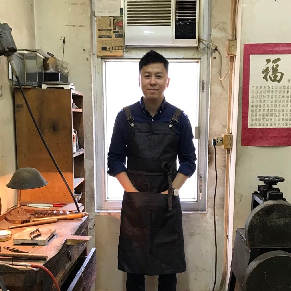 Terence Lee, the independent jewelry artist and master inspector behind HN Jewelry, standing in his traditional Hong Kong craft workshop.