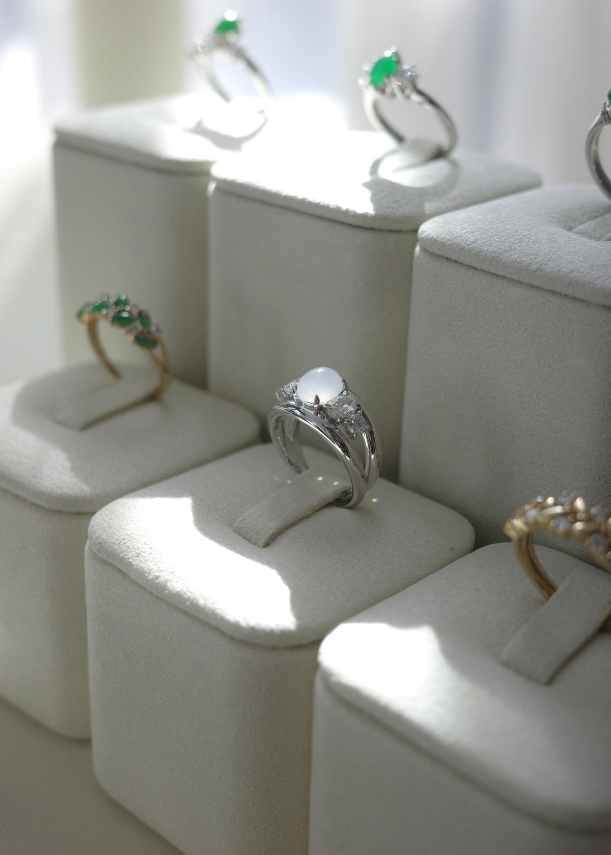 Close-up of oval and round brilliant accent diamonds surrounding icy white jade center stone.