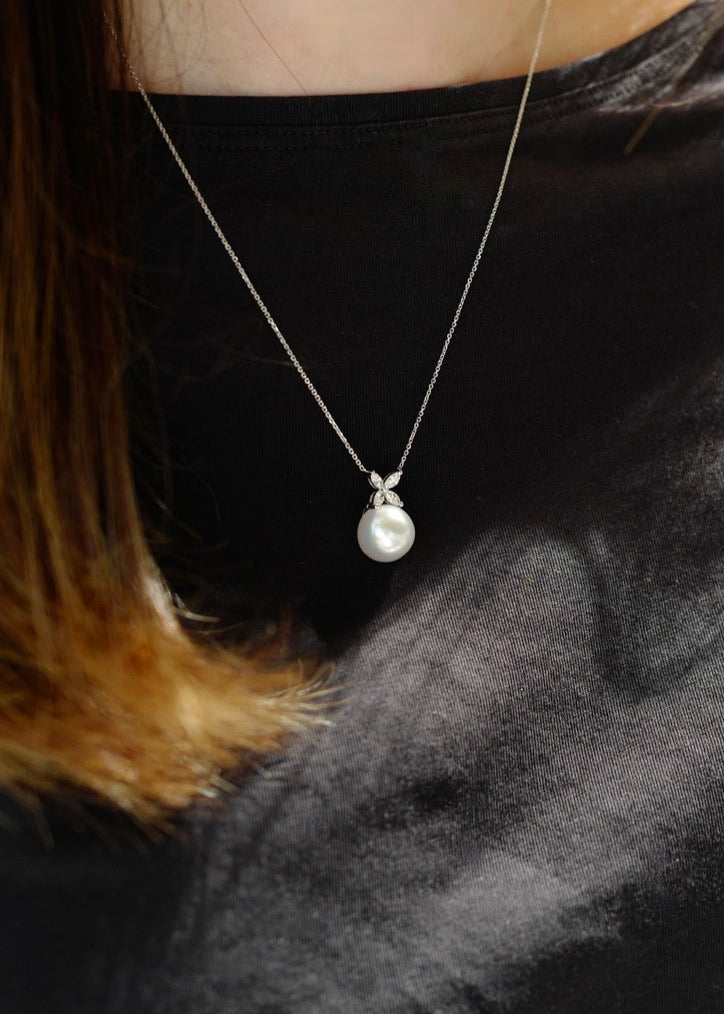 Pearl necklace on a person wearing a black top