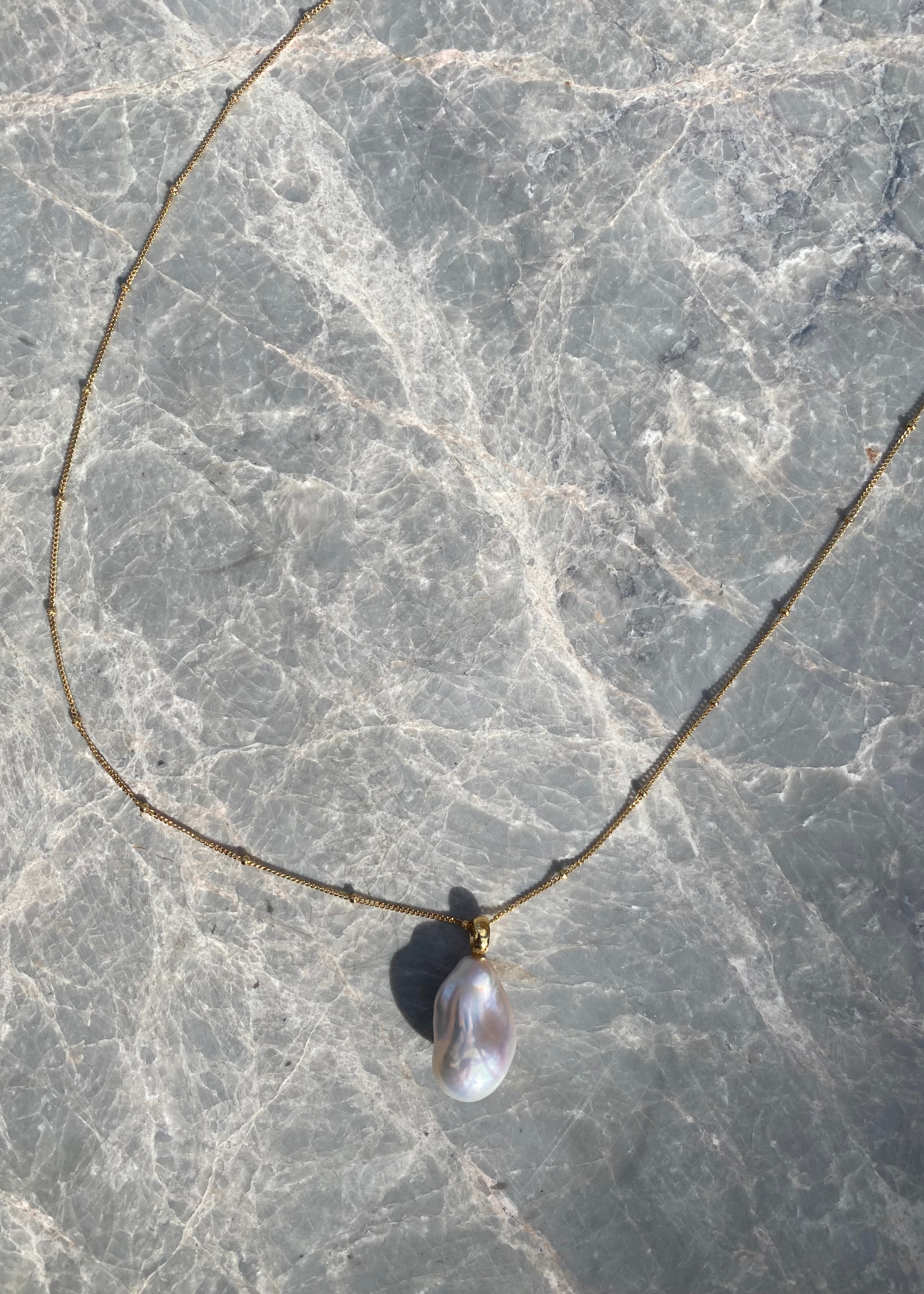 Necklace with a pendant on a marble surface