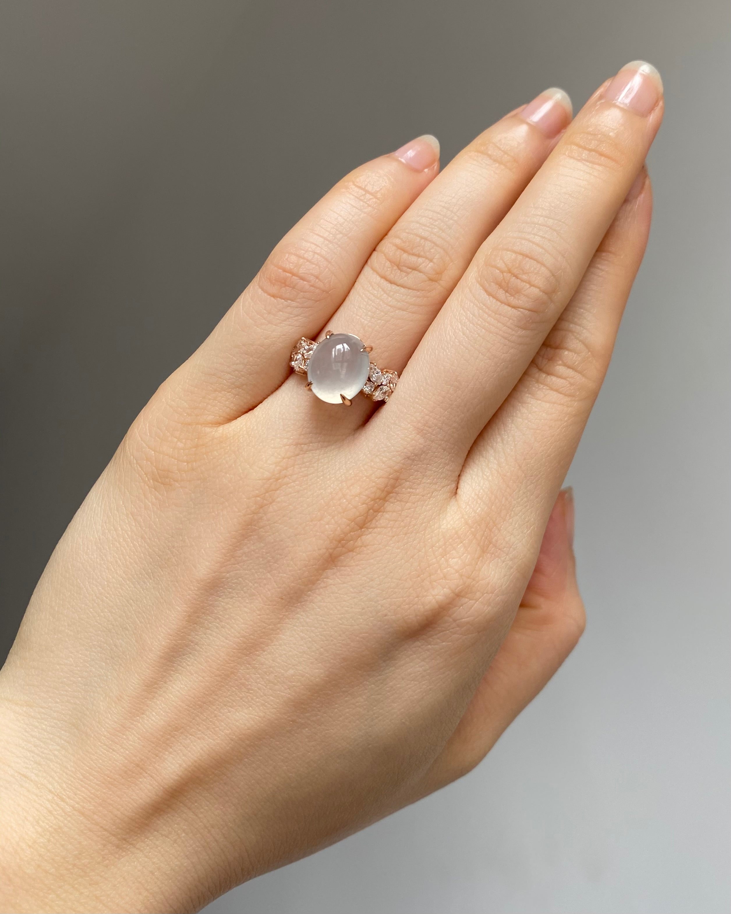 An unique natural icy white jade at the center along with marquise diamonds and round brilliant cut on the side