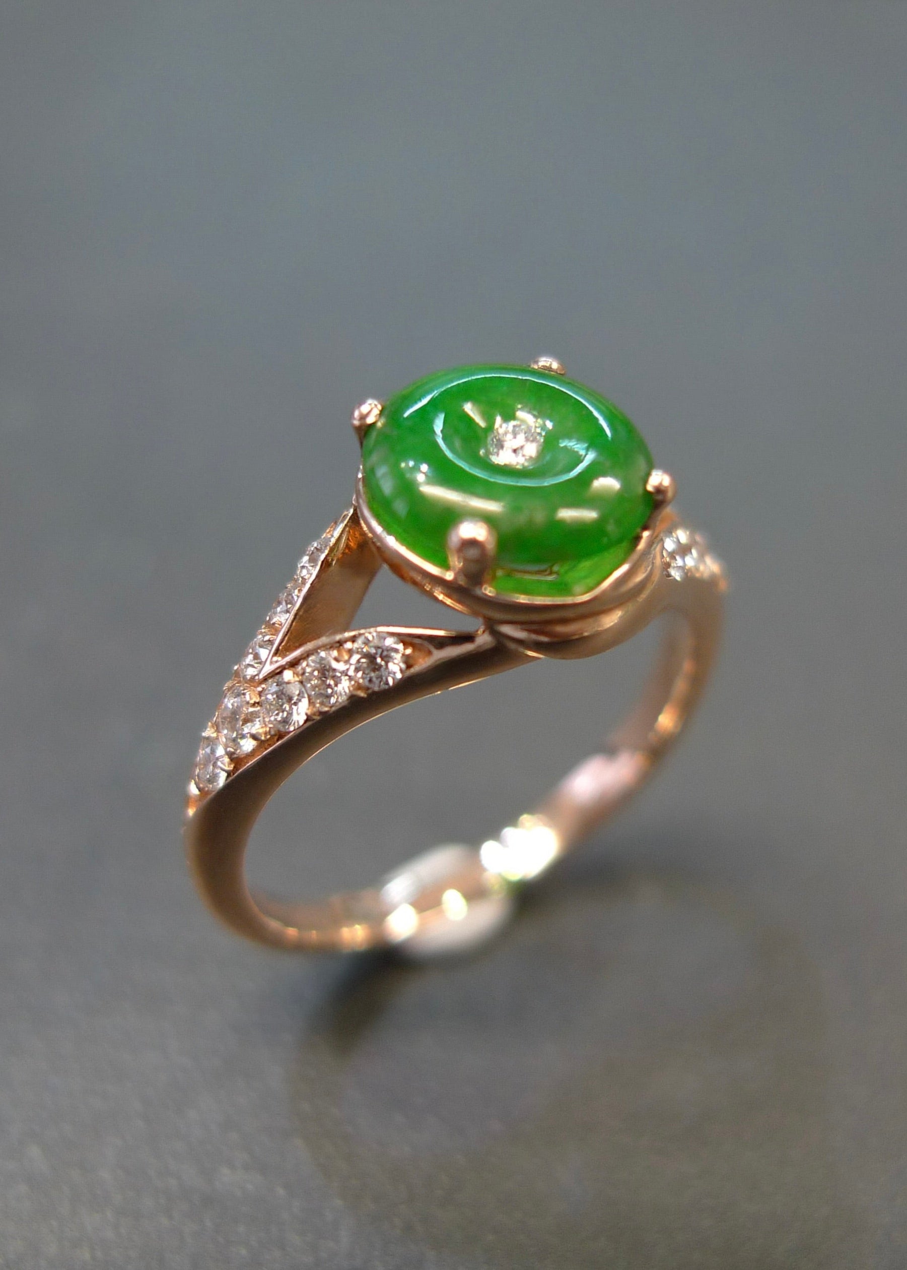 Gold ring with a green gemstone on a gray background