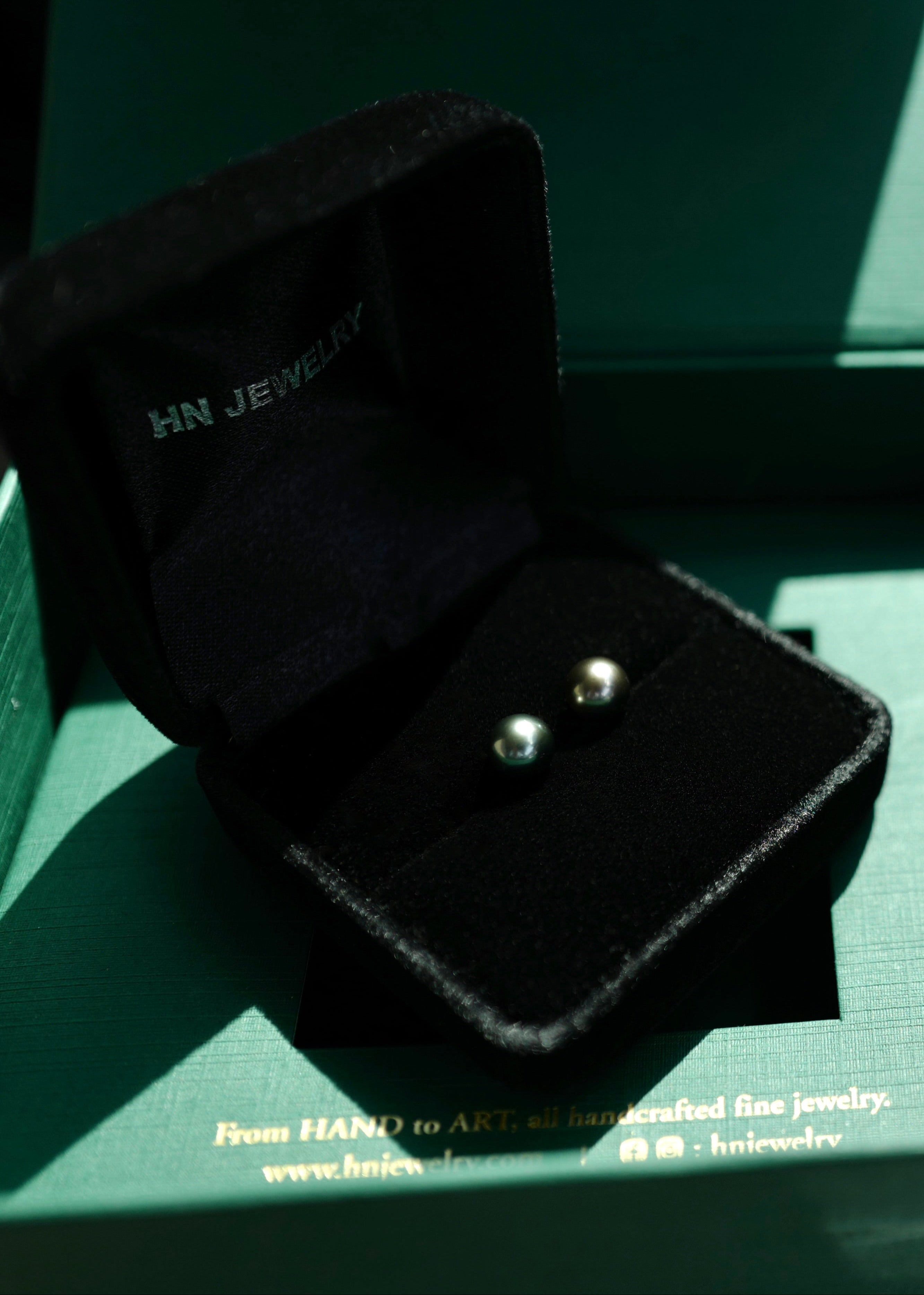 Black jewelry box with black pearl earrings, featuring 'HN Jewelry' branding.