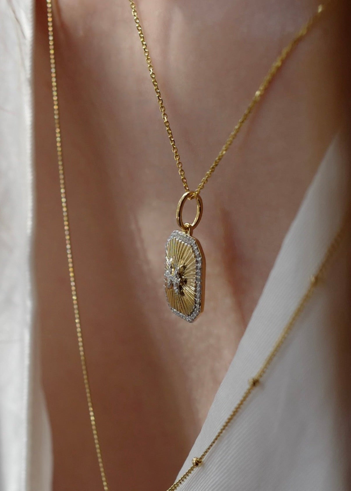 Gold necklace with a decorative pendant on a blurred background