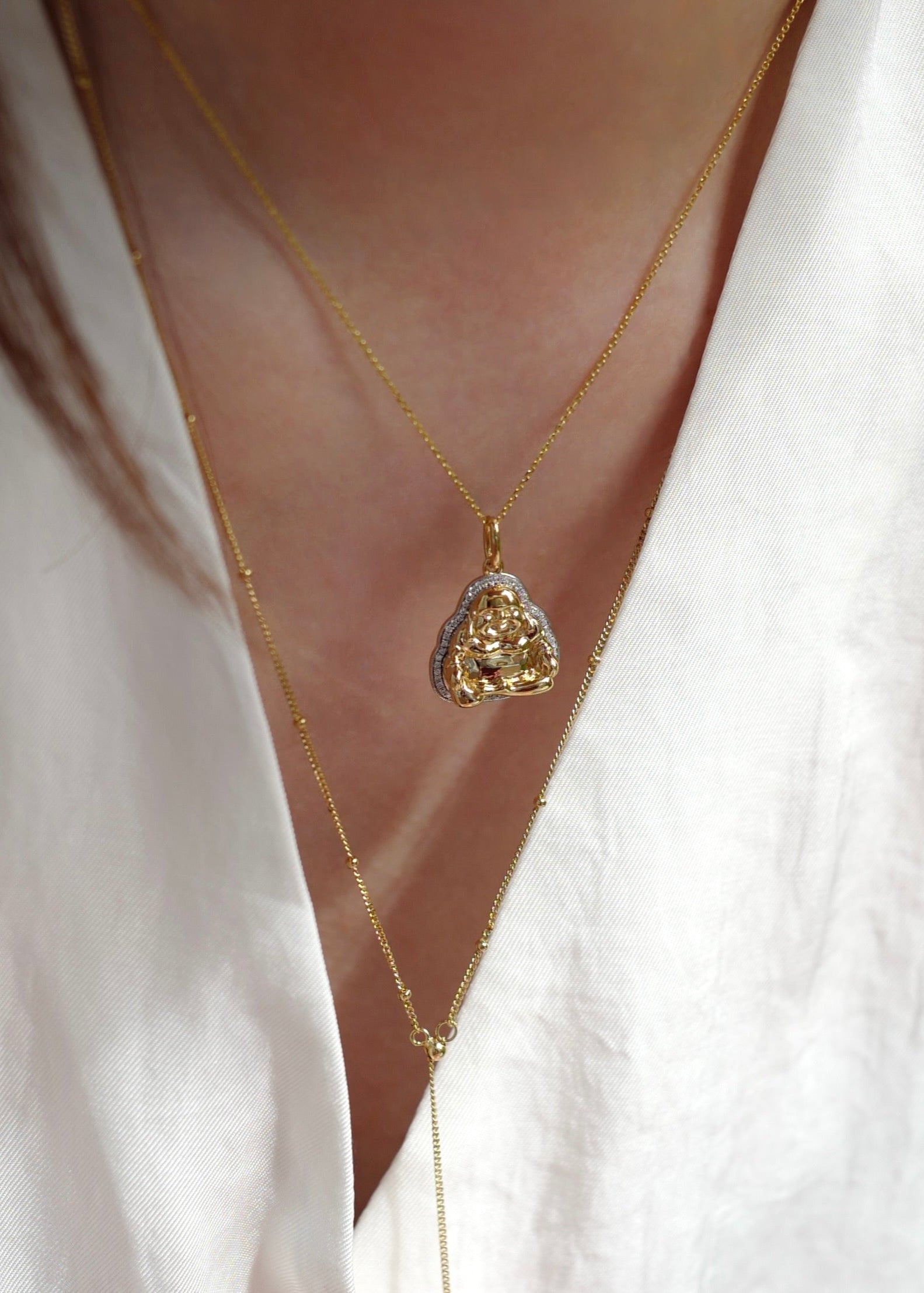 Gold necklace with a heart-shaped pendant on a white blouse