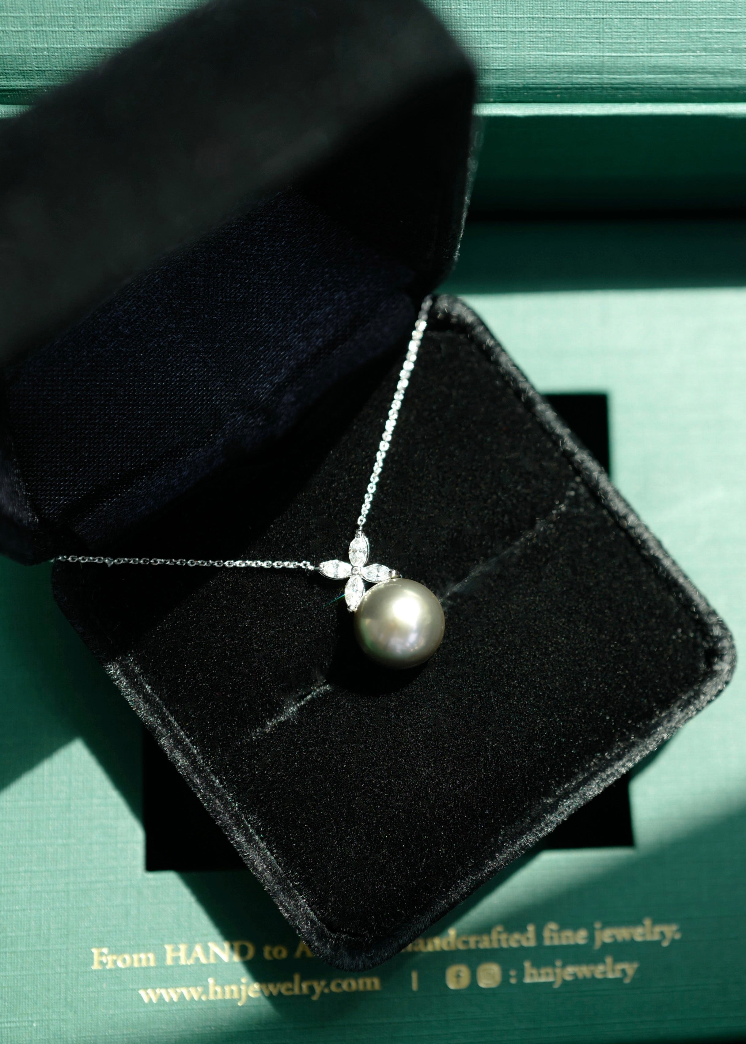 South Sea Black Pearl necklace on a black jewelry box with 'hnjewelry' branding.