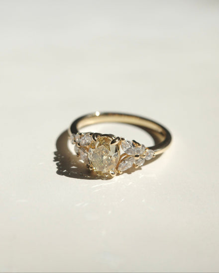 Gold ring with diamond cluster on a white background
