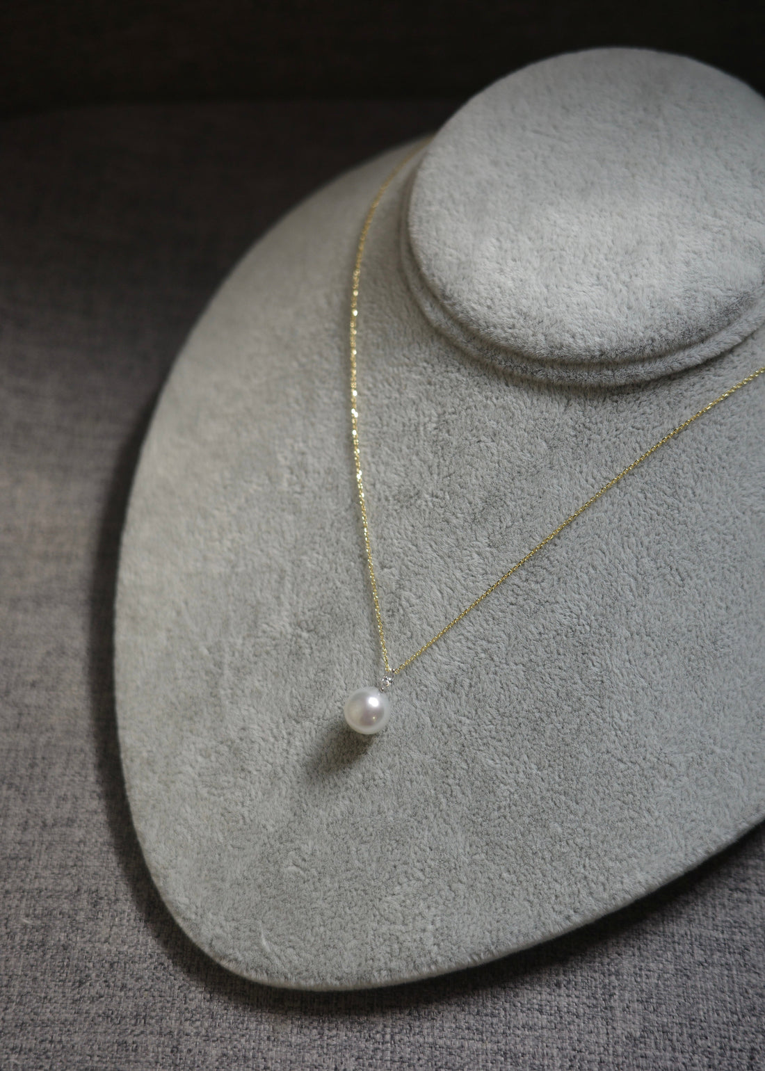 Pearl necklace on a gray jewelry display