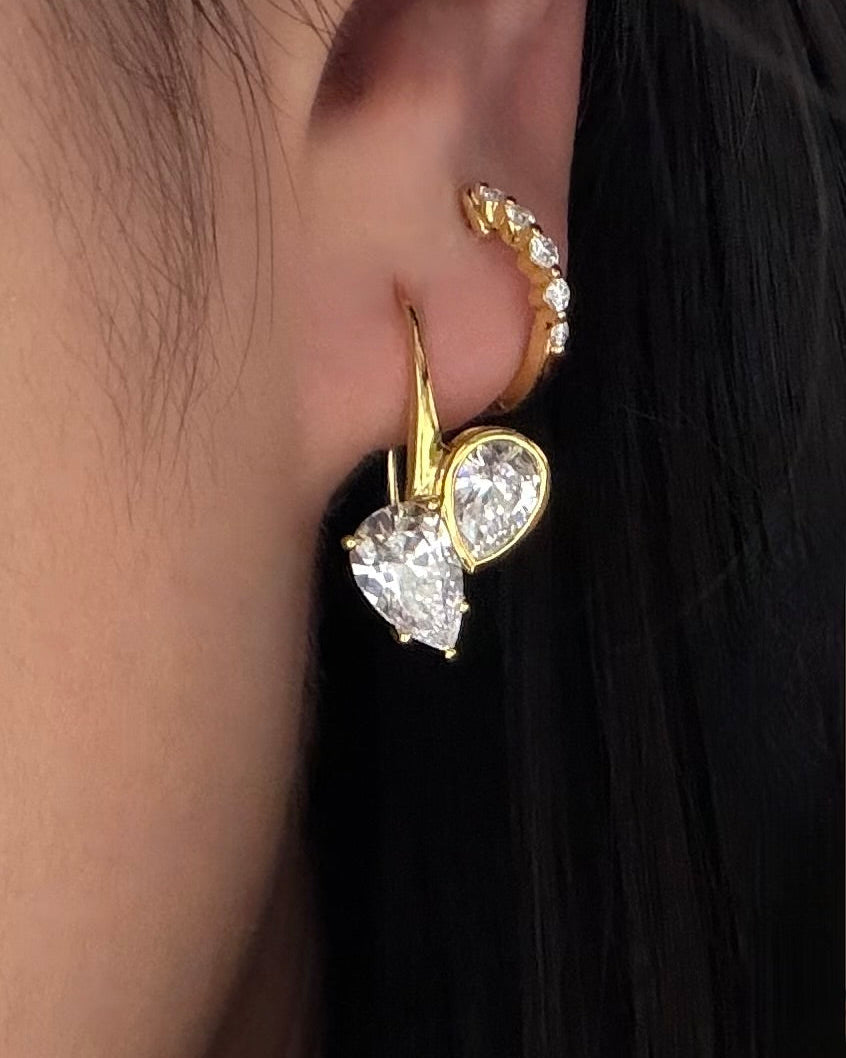 two pear diamonds set in polished gold dangle earrings
