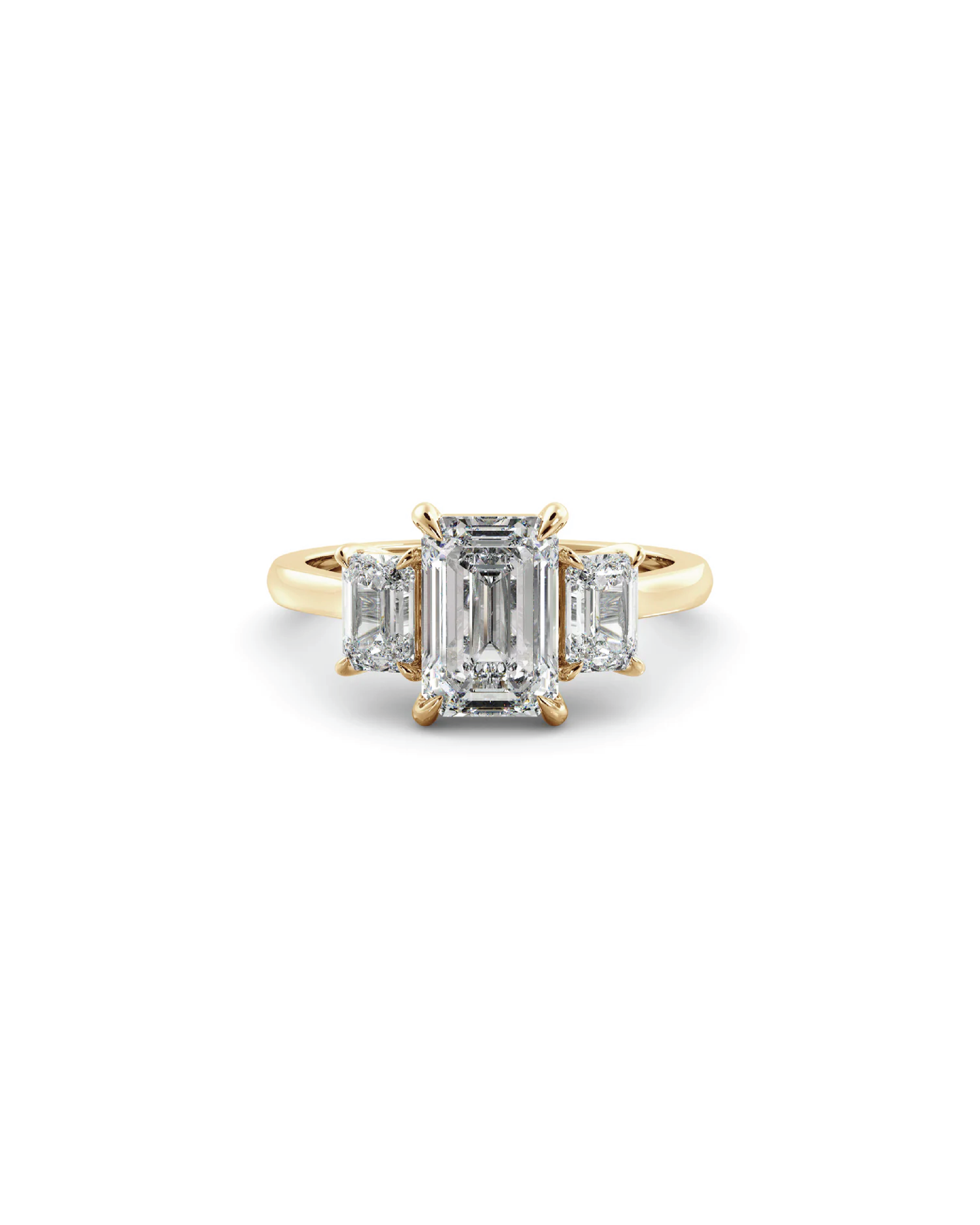 An 18K yellow gold ring with a central emerald diamond flanked by two accent emerald diamonds, all set in a white background.