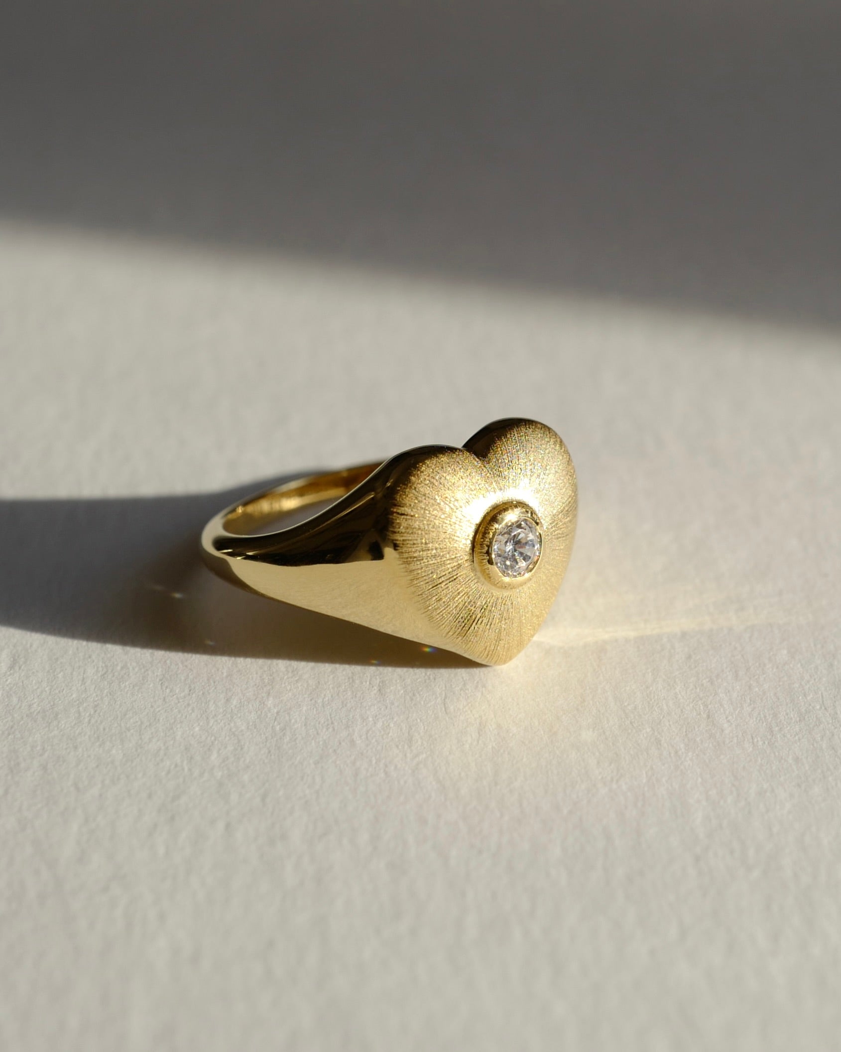 Gold heart signet ring with round brilliant cut diamond
