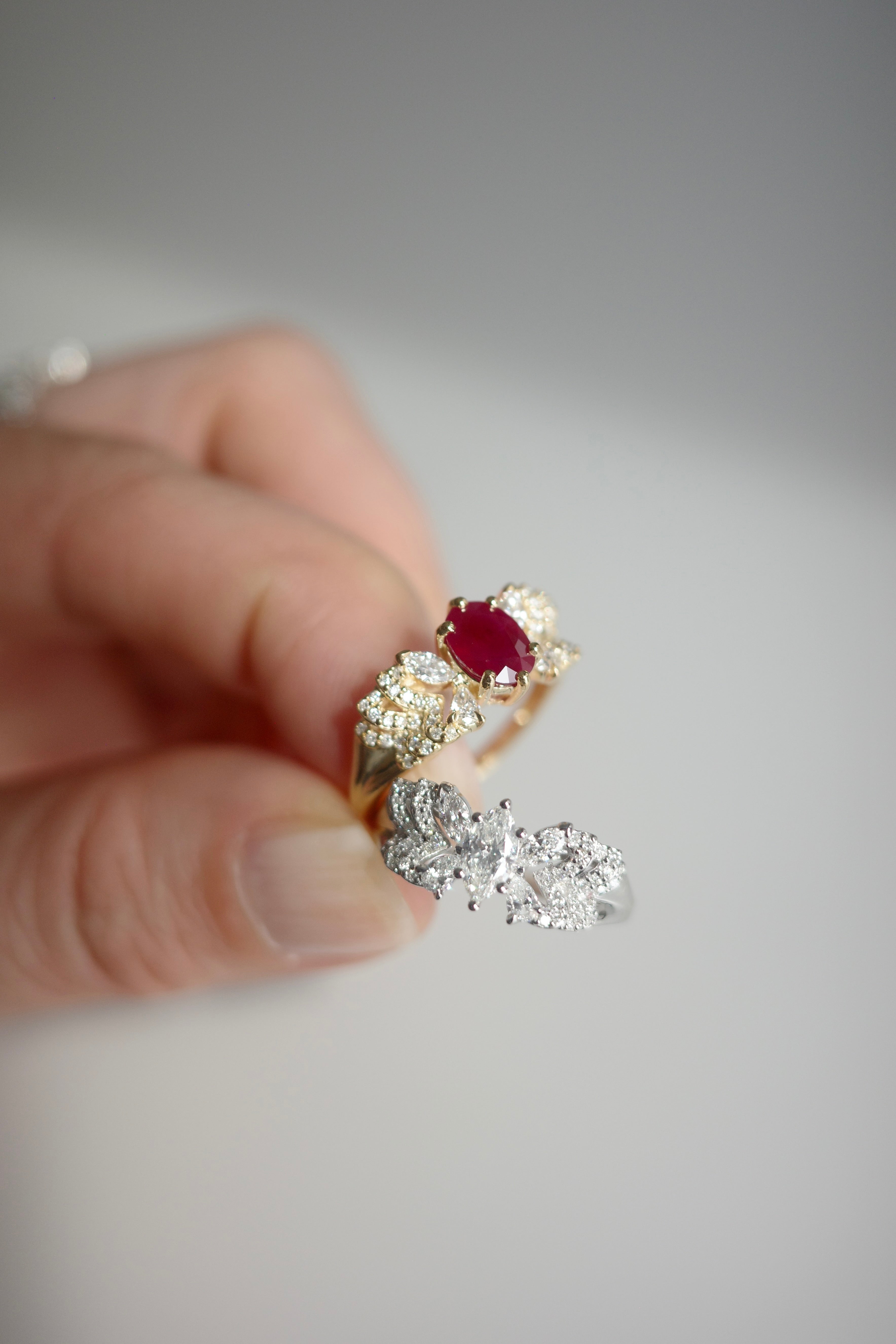 Close up of an oval ruby engagement ring with marquise and pear shaped diamonds