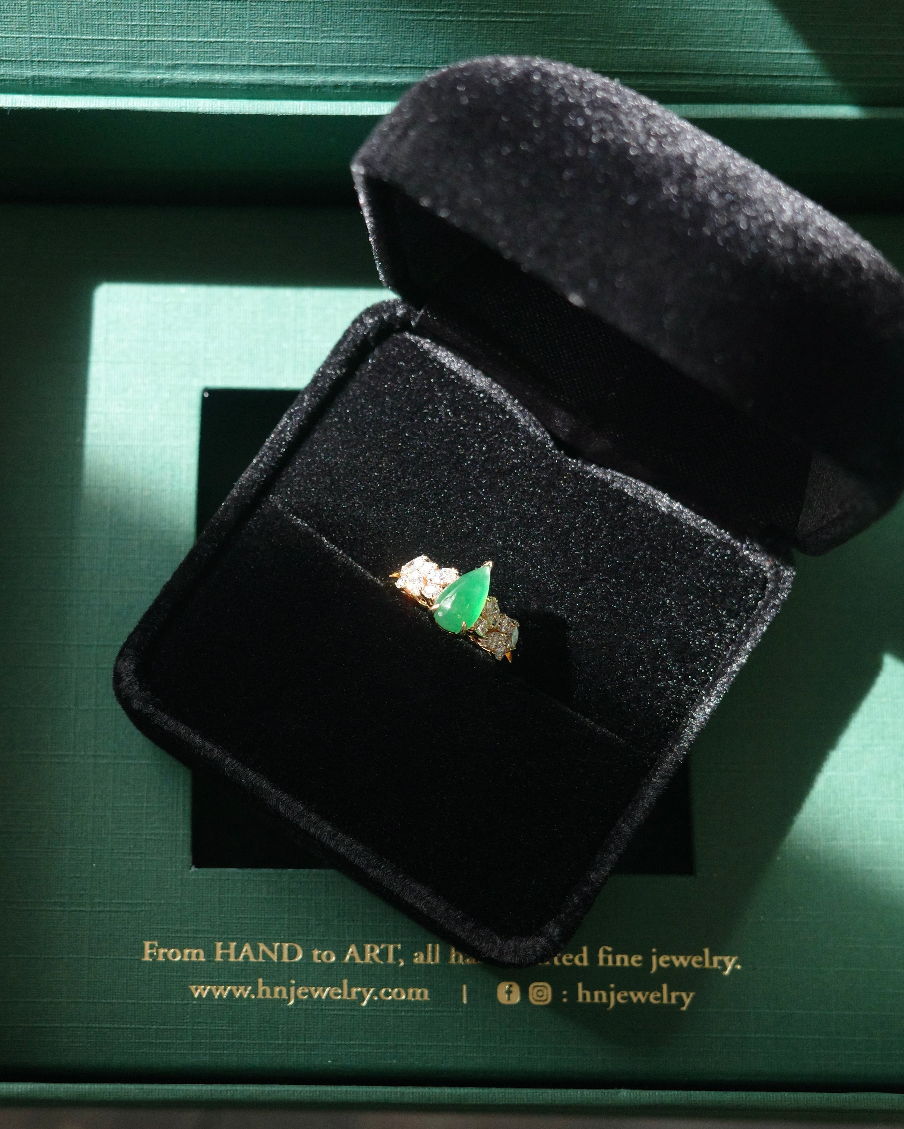 Jewelry box with a green jade ring on a green background