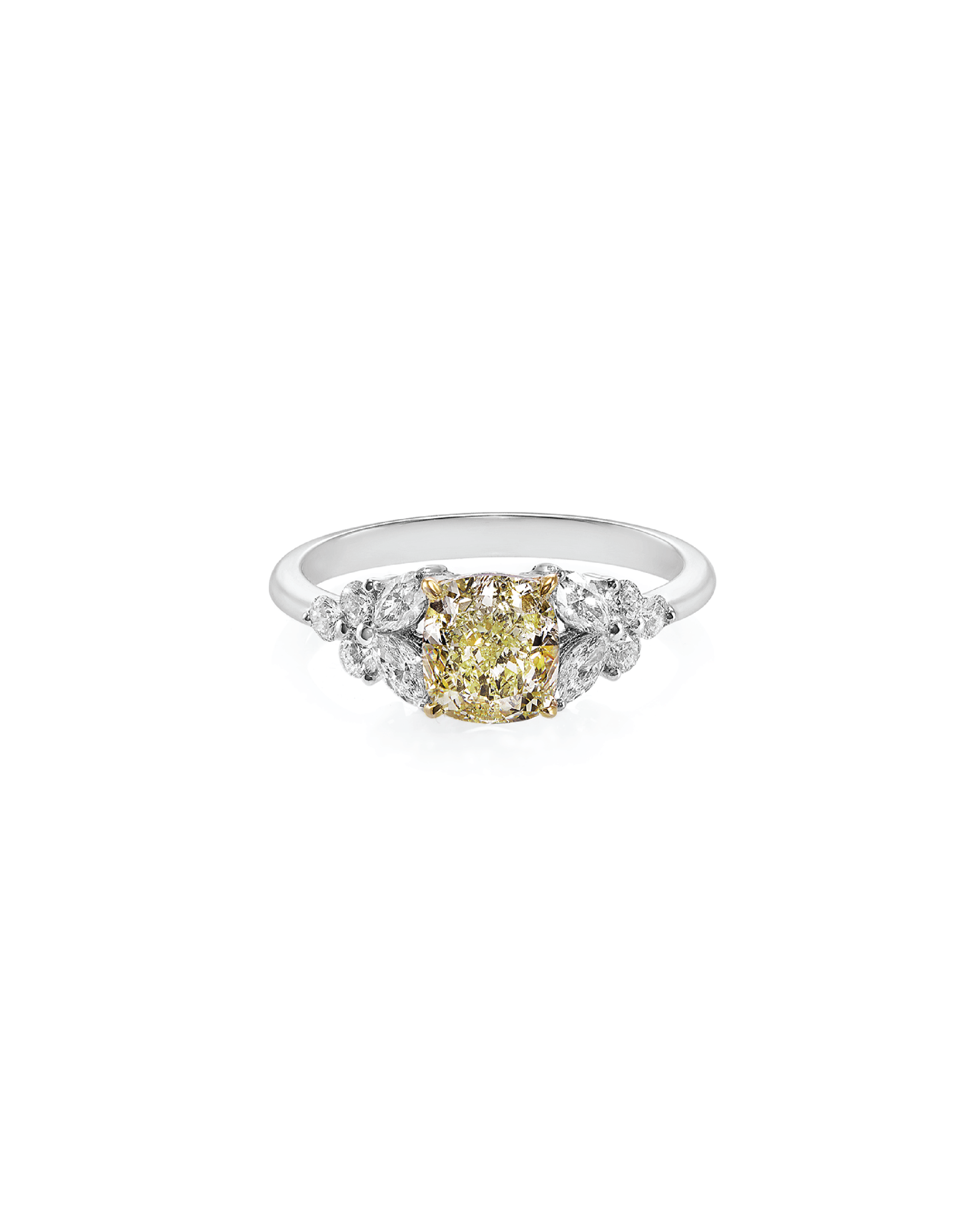 A cushion cut yellow diamond ring with round and marquise cut diamonds set in a white gold band