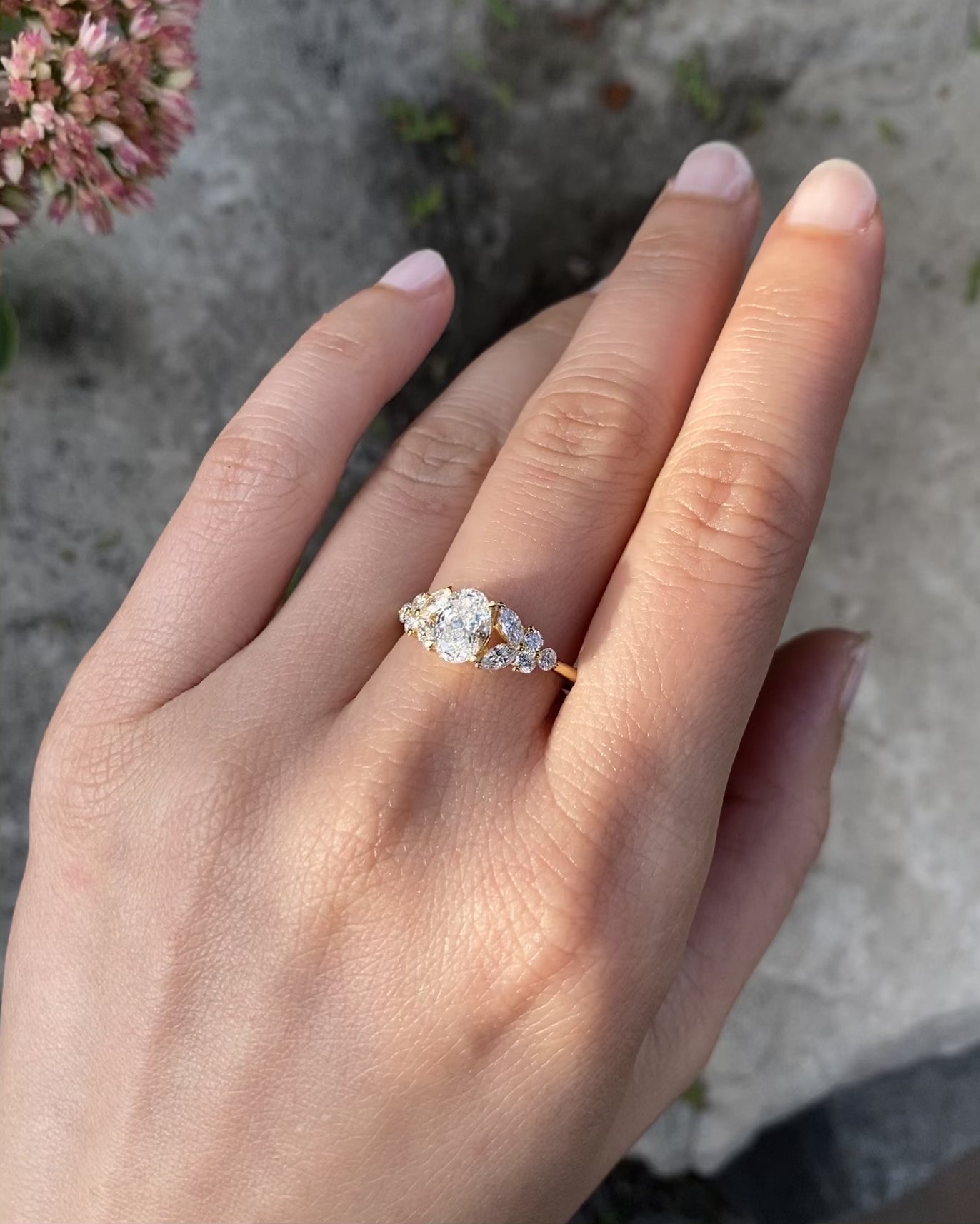 A unique engagement ring set with an 0.70ct oval diamond at the center along with marquise diamond and round brilliant cut diamond on the side. 