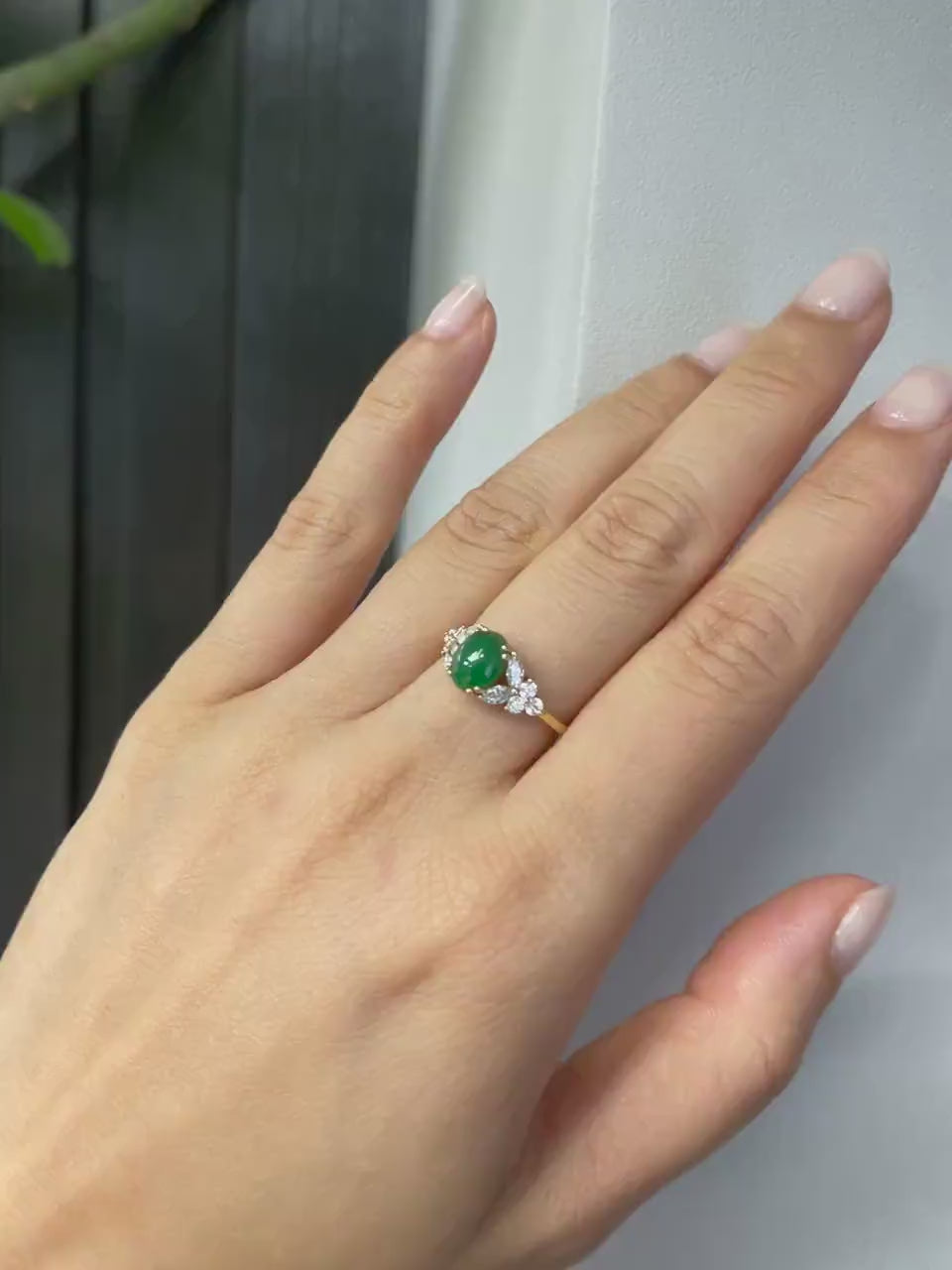 A model wearing a natural green jade at the center along with marquise diamond and round brilliant cut diamond on the side.