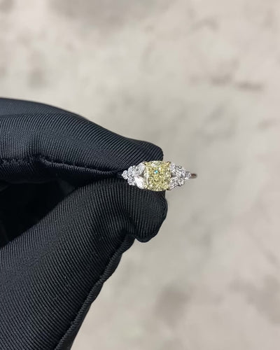 An engagement ring set with cushion yellow diamond at the center along with marquise diamond and round brilliant diamonds on the side