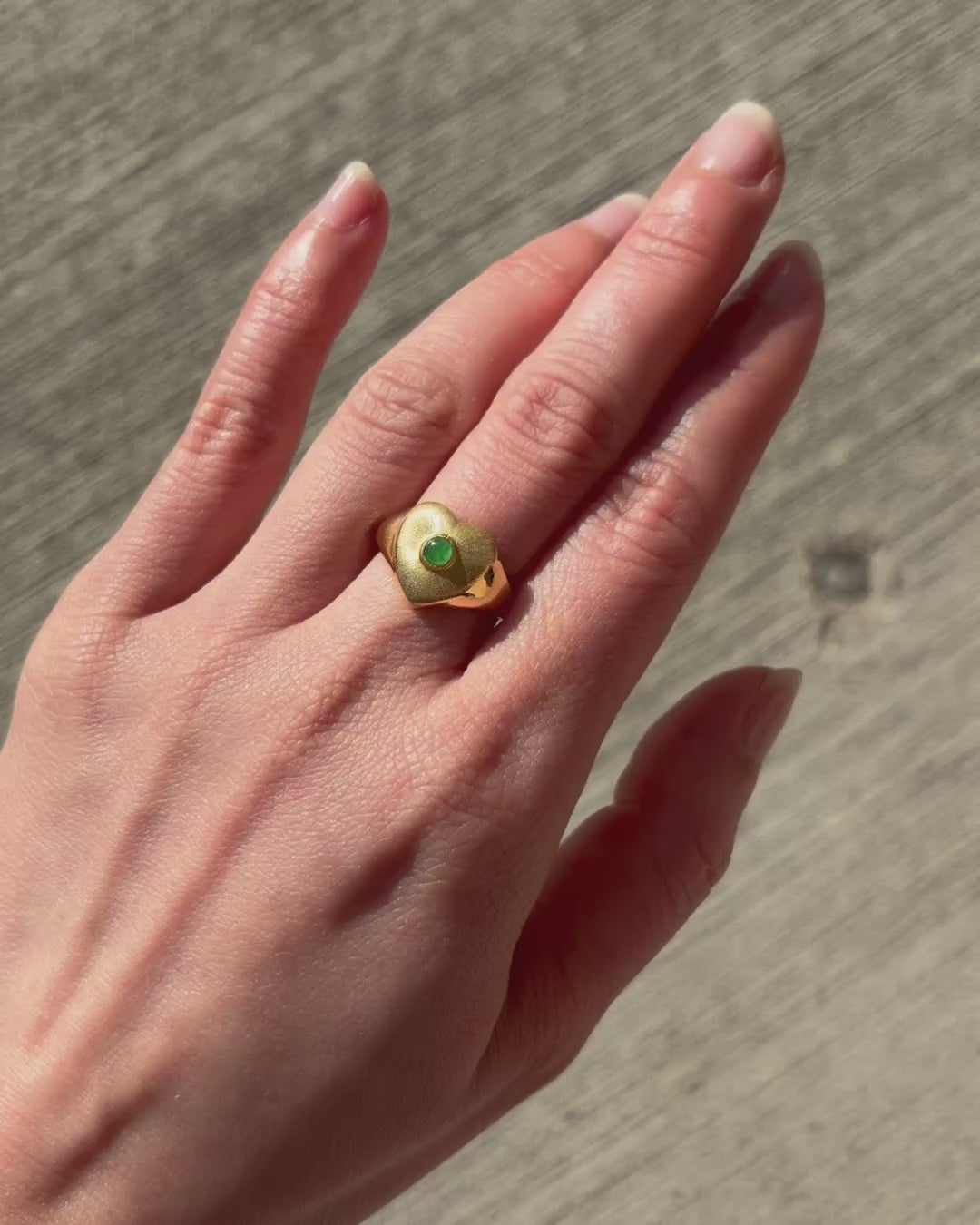 Bold gold heart ring with natural round jade at the center

