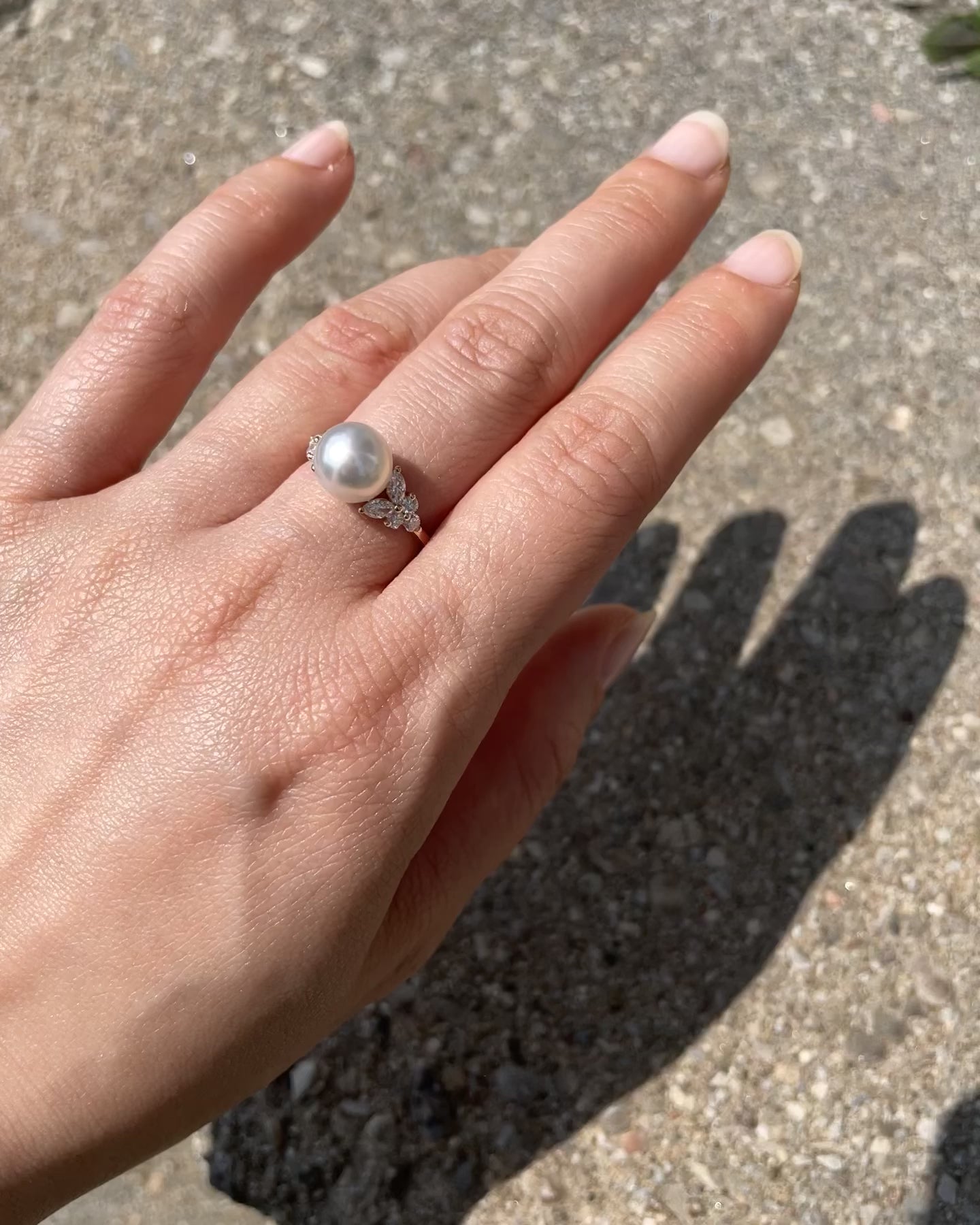 model wearing a south sea pearl and marquise diamond engagement ring in yellow gold