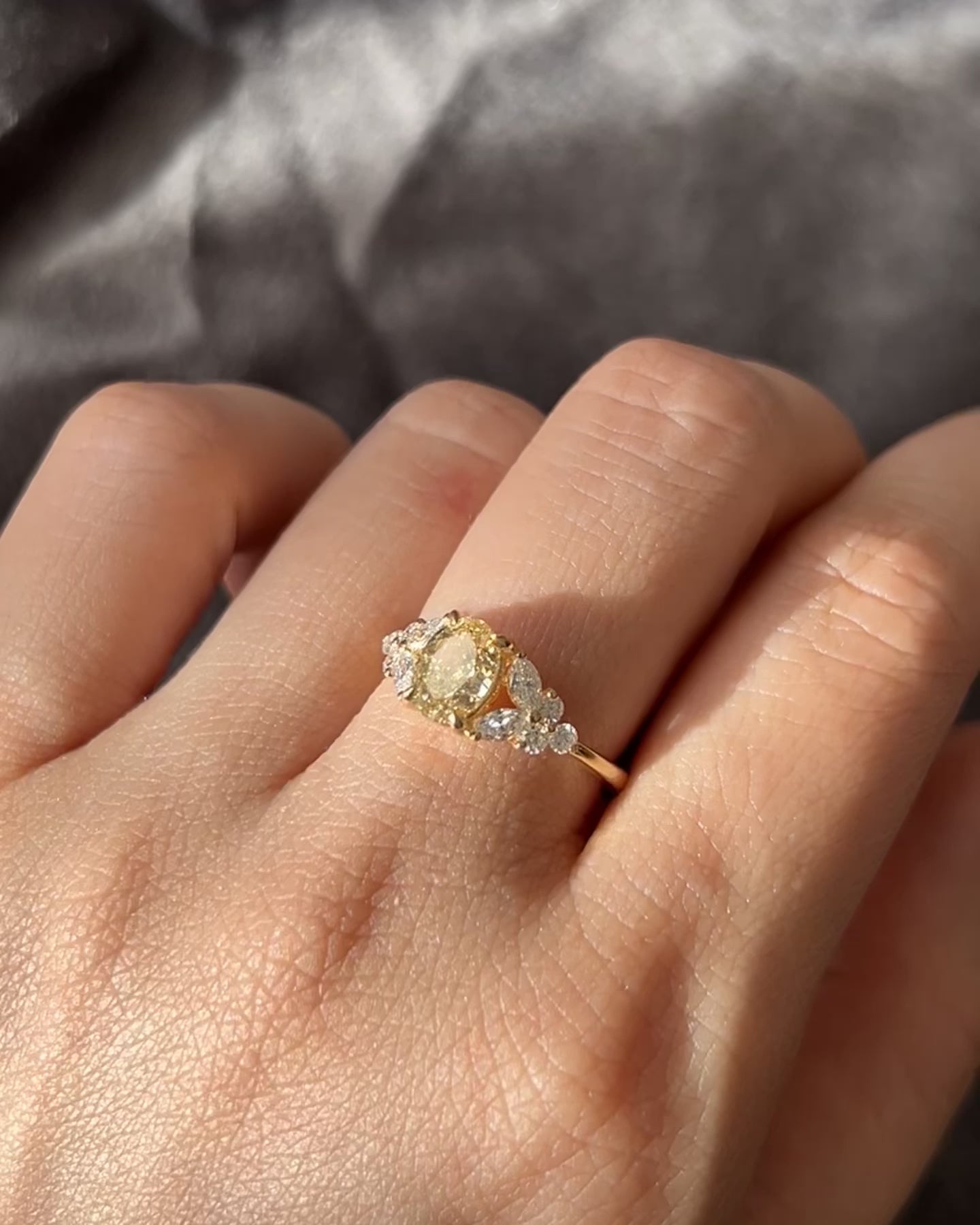 An engagement ring set with oval cut fancy yellow diamond at the center along with marquise diamond on the side