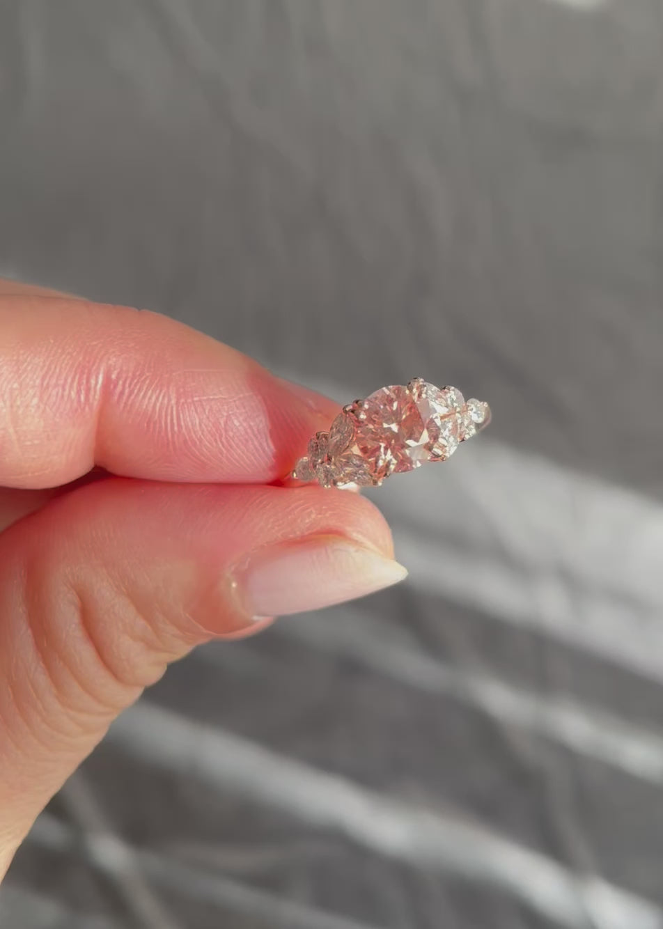 a fancy pink lab grown diamond and marquise diamond engagement ring in rose gold