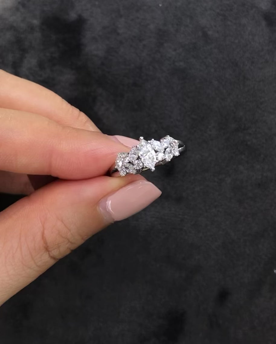 A engagement ring with 0.30ct marquise diamond at the center along with round brilliant and marquise diamonds on the side in 14k yellow gold