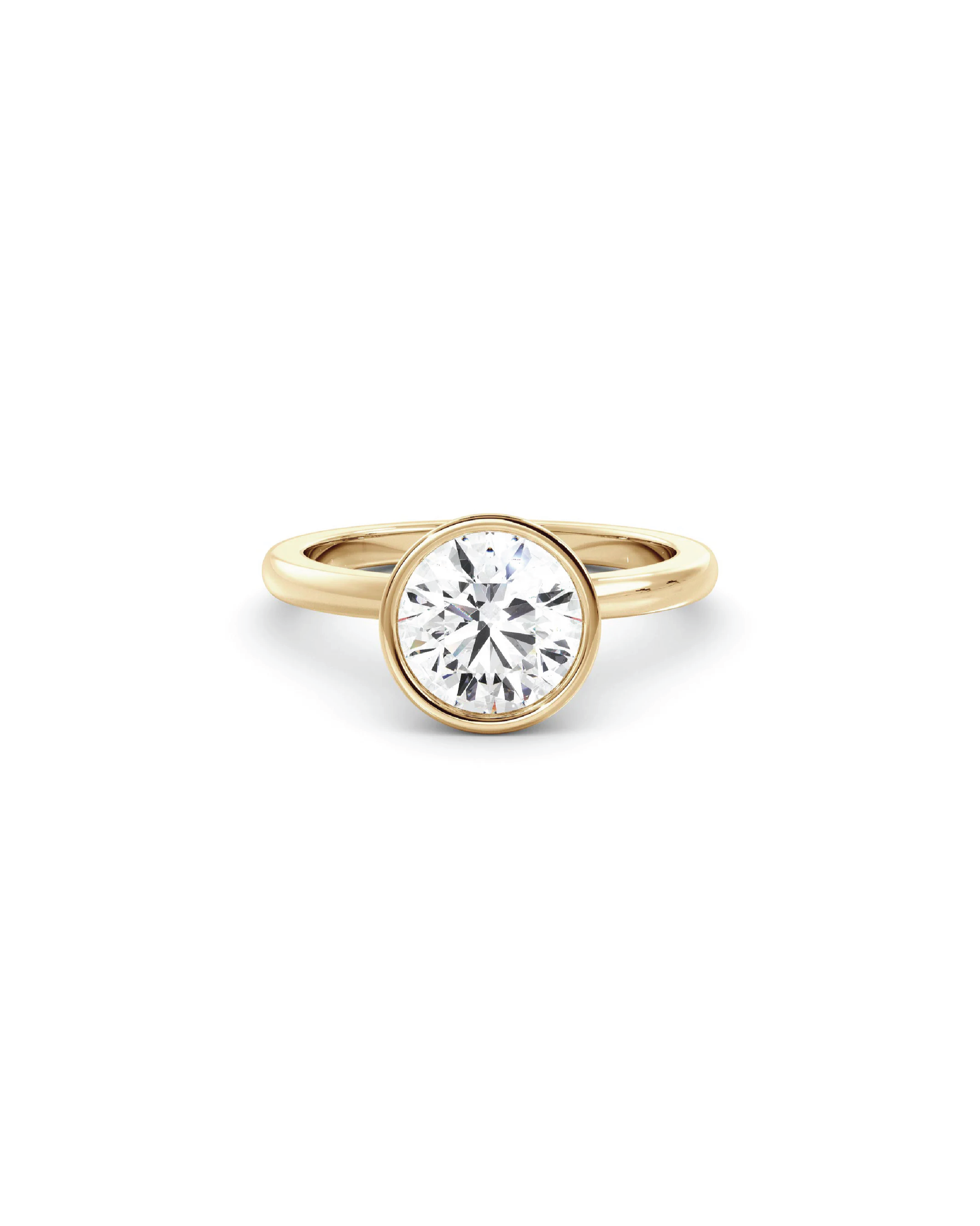 An image of a round bezel solitaire diamond ring with a yellow gold band on a white background.
