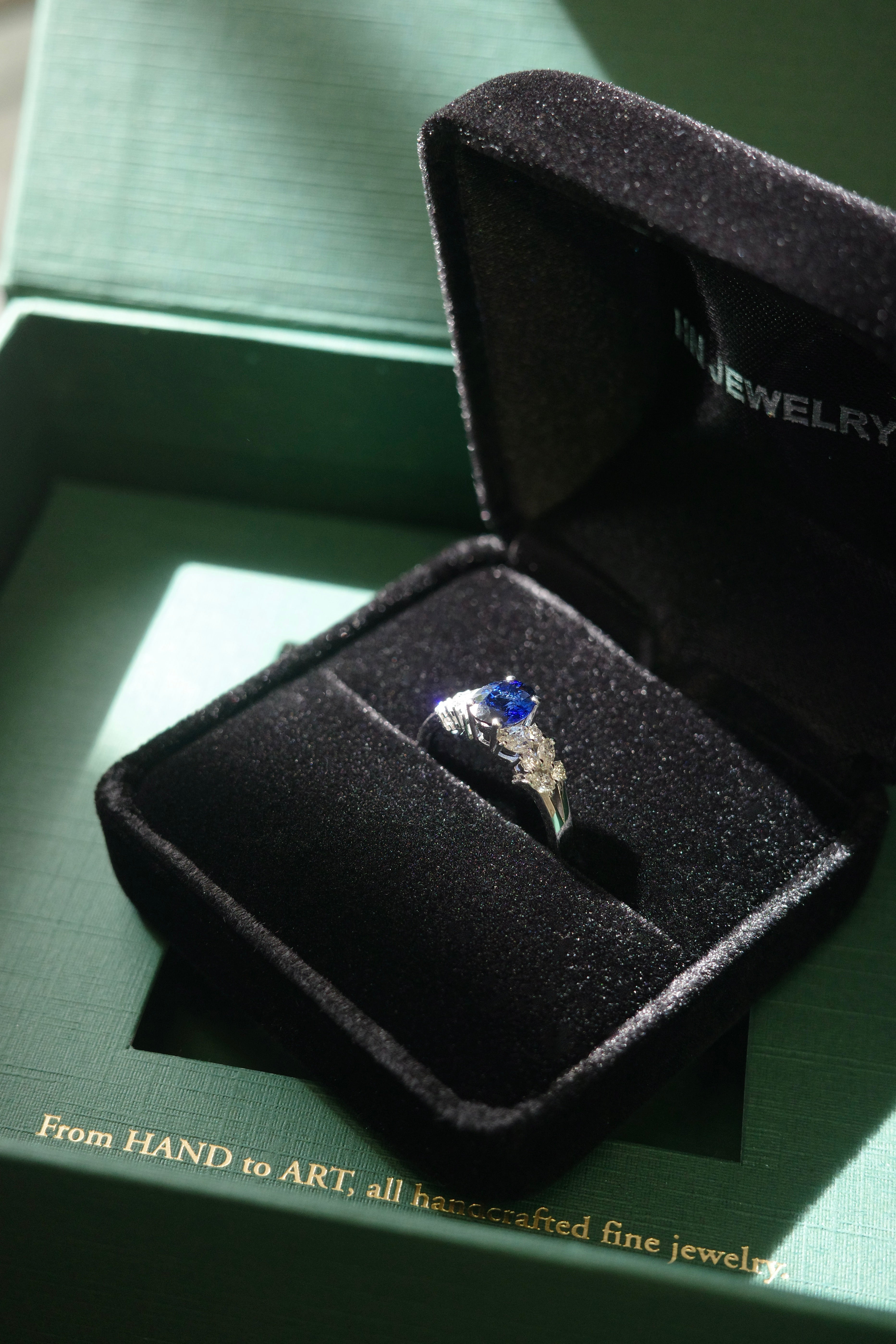 Fine jewelry oval sapphire ring with marquise diamond side stones on HN Jewelry package box