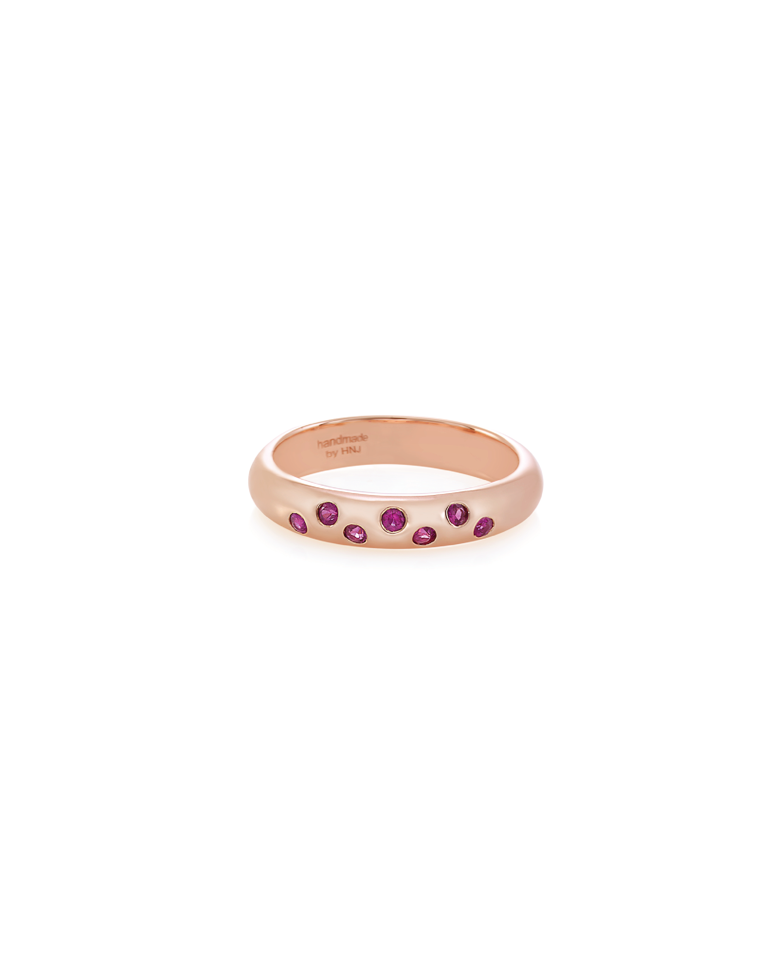 A band ring with multiple round rubies set in a 14K rose gold band.