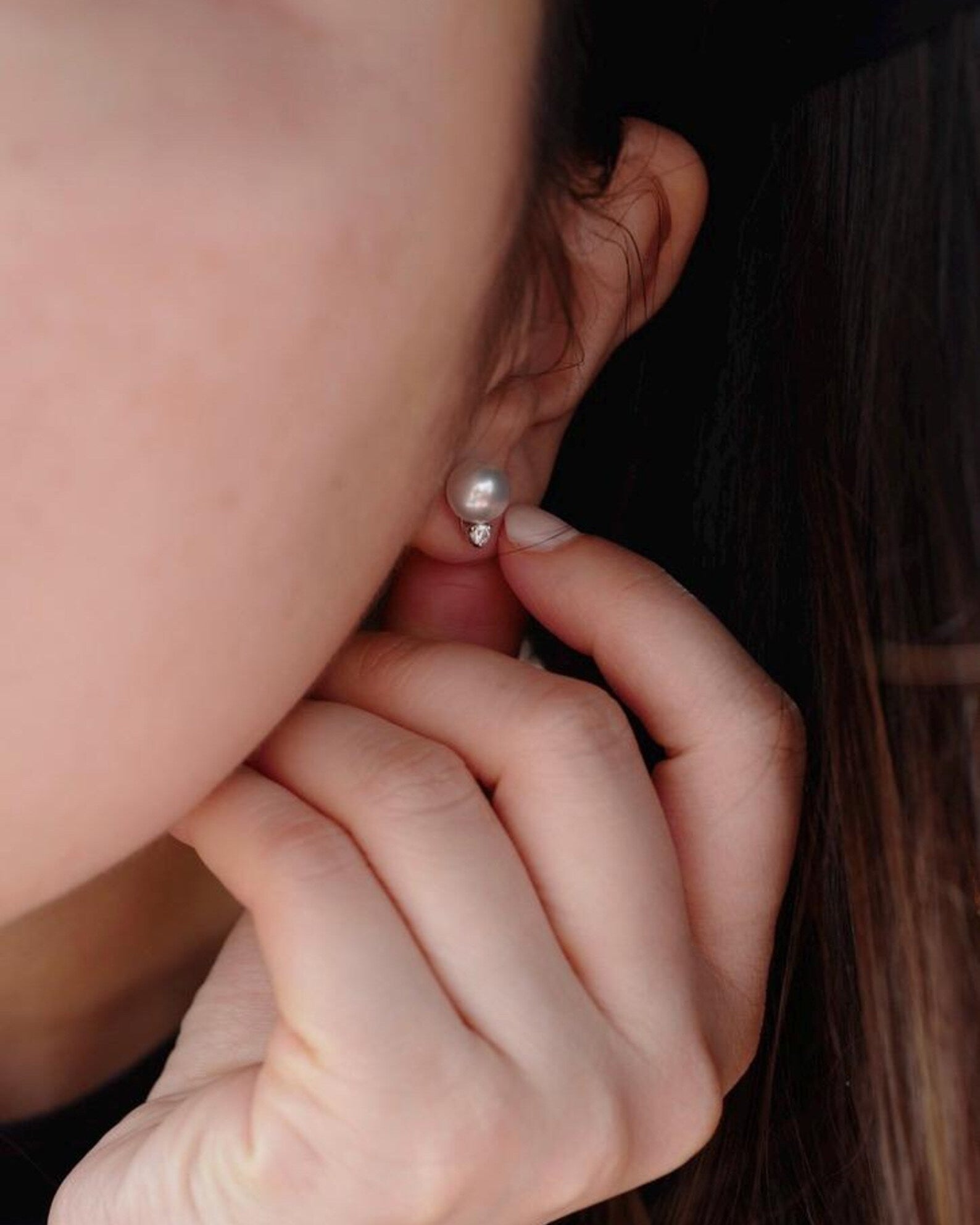 Close-up of a person wearing a south sea white pearl earrings