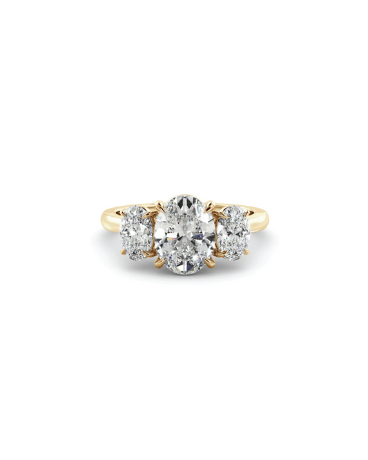 Gold ring with three diamond stones on a white background
