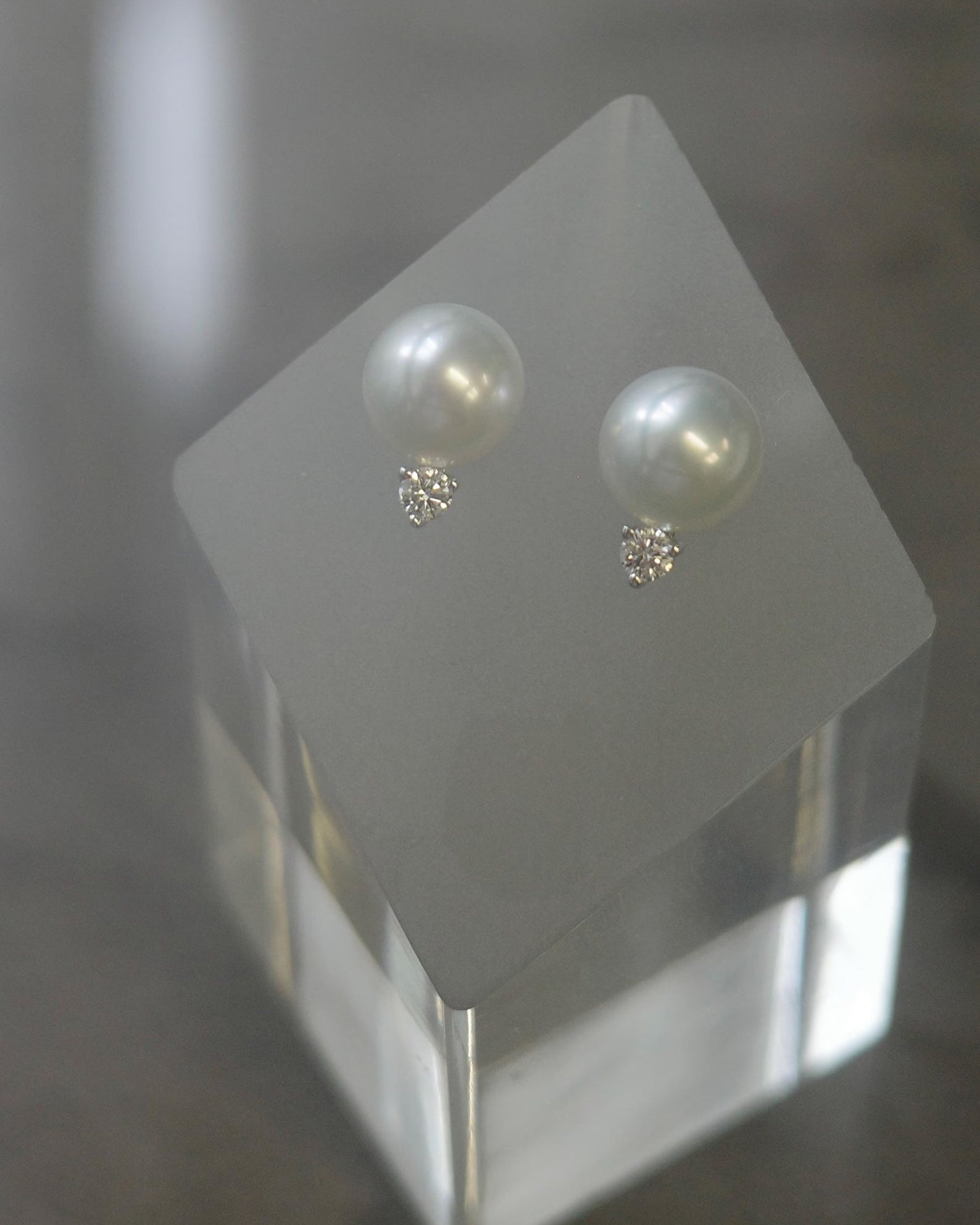 Pair of white pearl earrings on a stand