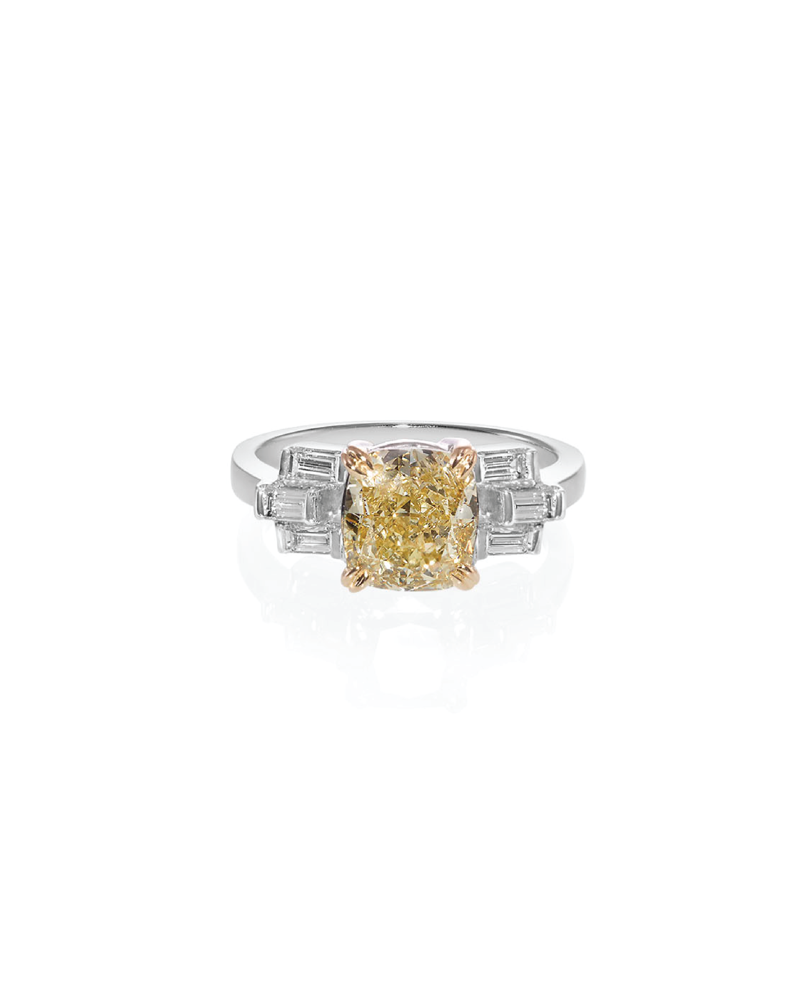 Two-tone ring with a yellow gemstone on a white background